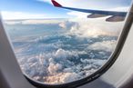 Wolken und Weite aus einem Flugzeugfenster beobachtet