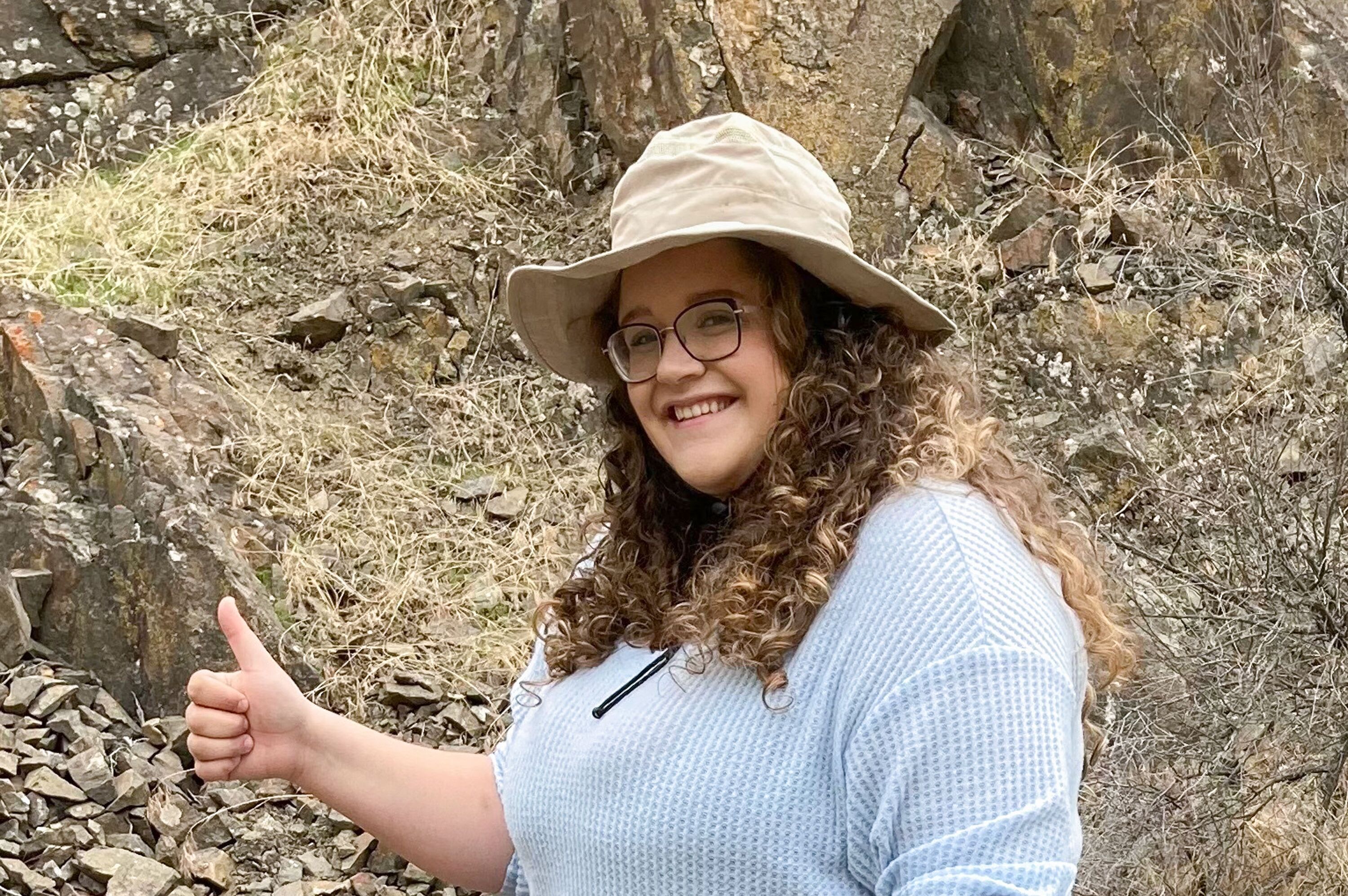 Jada Glen trägt einen Hut und reckt lächelnd den Daumen in die Luft.