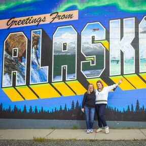 Maike und Bettina vor einem Alaska Schriftzug