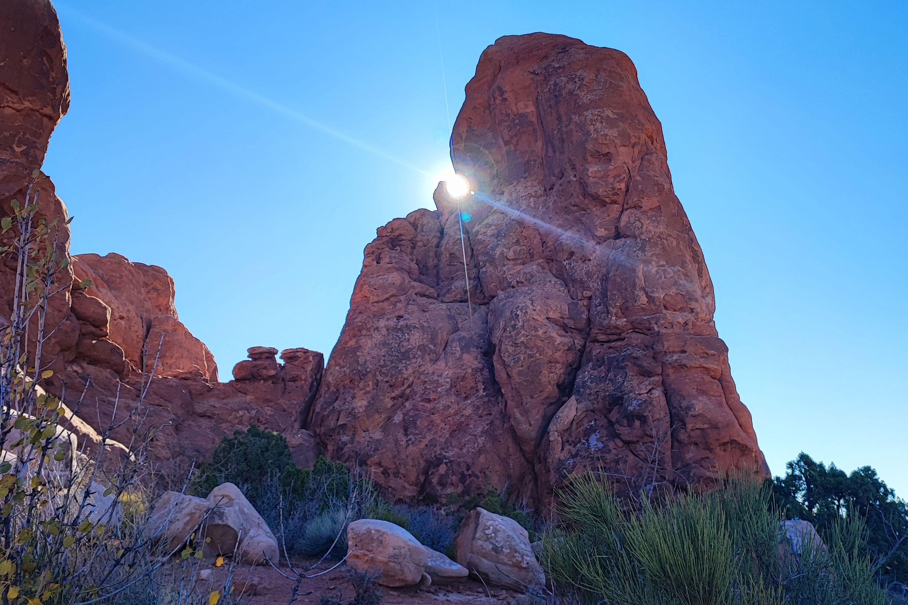 Sonne hinter einem Felsen im Arches Nationalpark