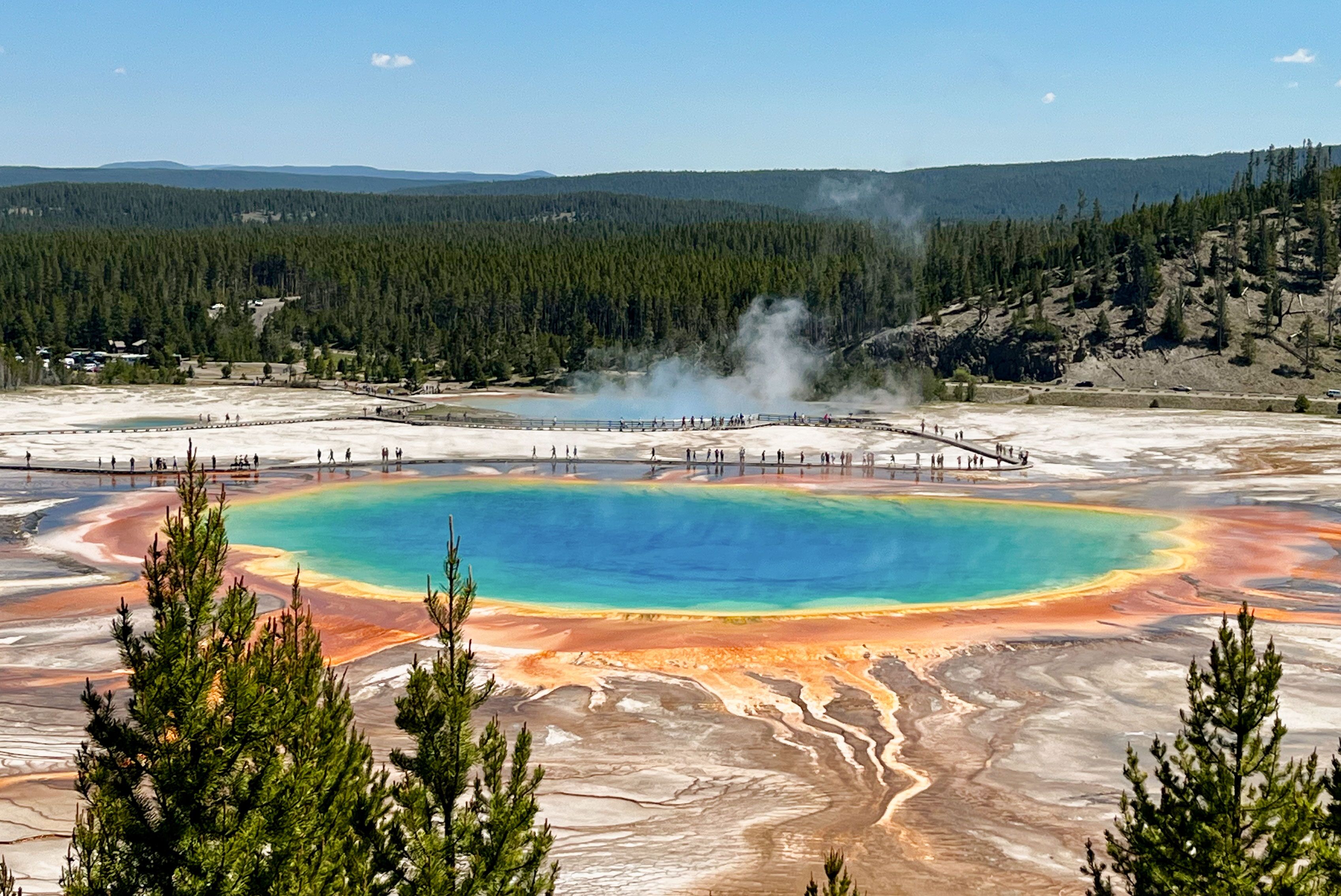 Von einem Aussichtspunkt aus auf die Grand Prismatic Spring Thermalquelle im Yellowstone National Park blicken
