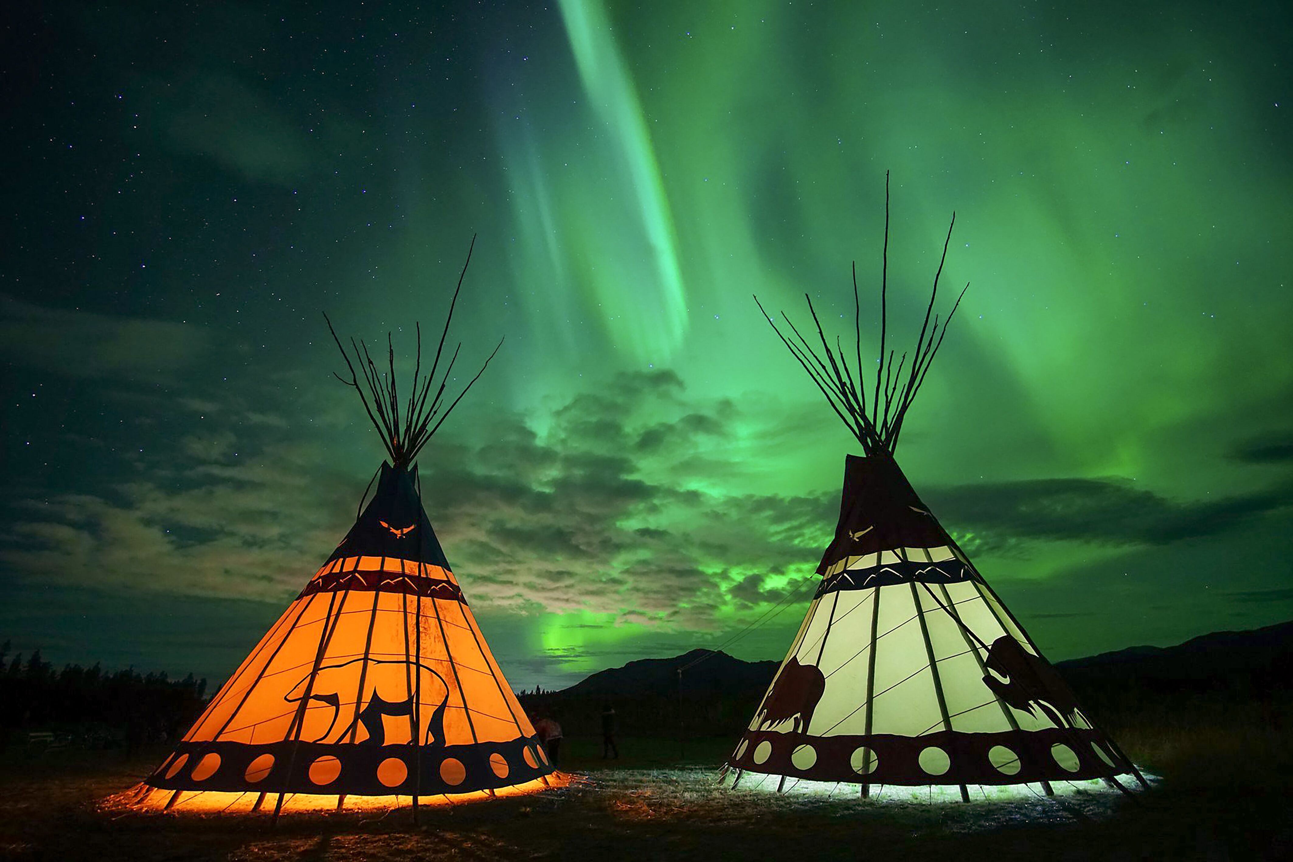 Romantische Nordlichter über Tipi Jurten im Arctic Range Adventure in Yukon