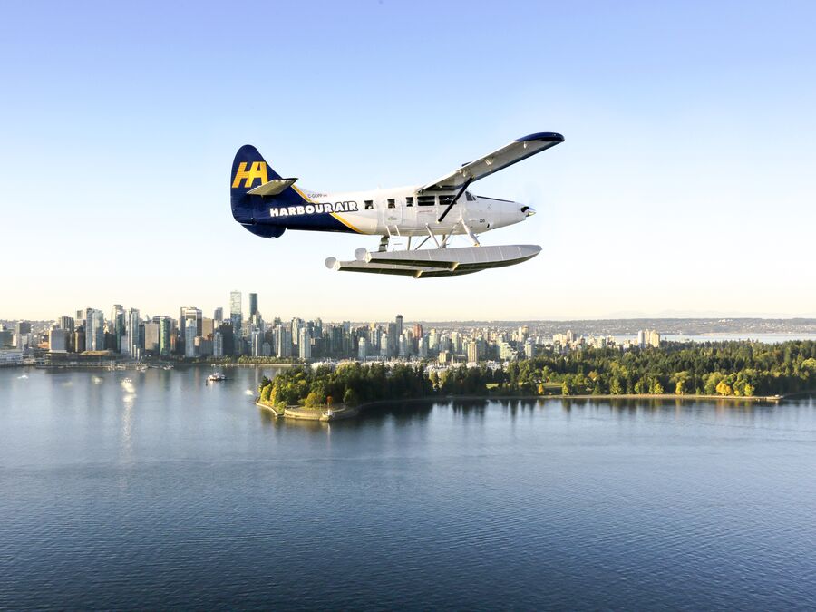 Ein Wasserflugzeug der Harbour Air vor der Skyline von Vancouver in Kanada