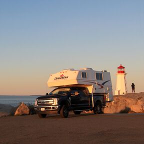 Der TCA Truck Camper von CanaDream bei Sonnenuntergang am Leuchtturm in Peggy's Cove, Nova Scotia