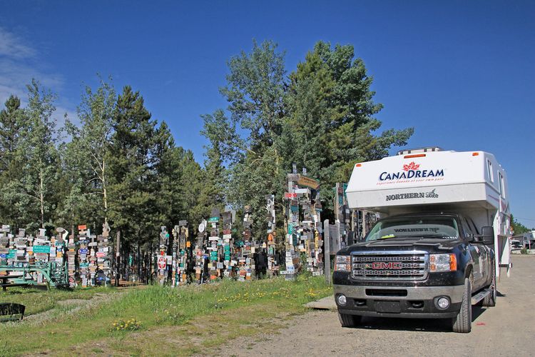 Ein CanaDream TCA Truck Camper in Watson Lake Signpost Forest auf dem Alaska Highway in Yukon