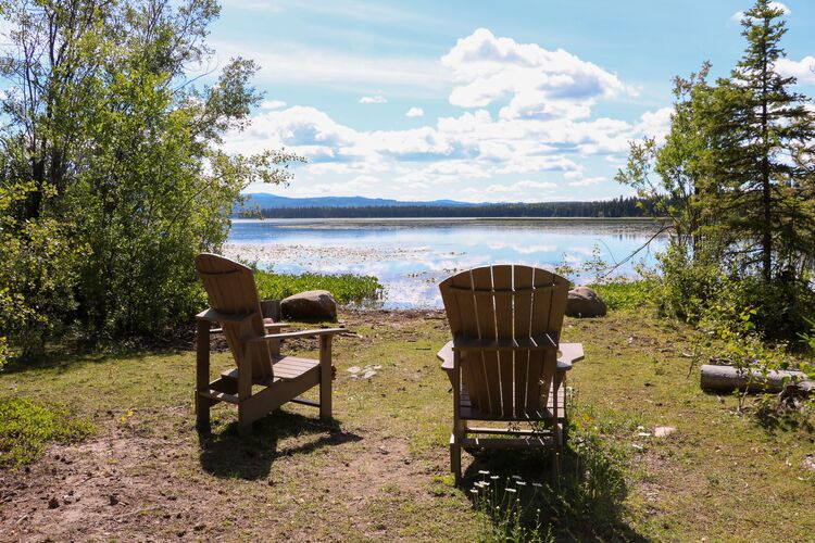 Zwei Stühle überblicken den Spout Lake an der Ten-ee-Ah Lodge in Lac la Hache, British Columbia