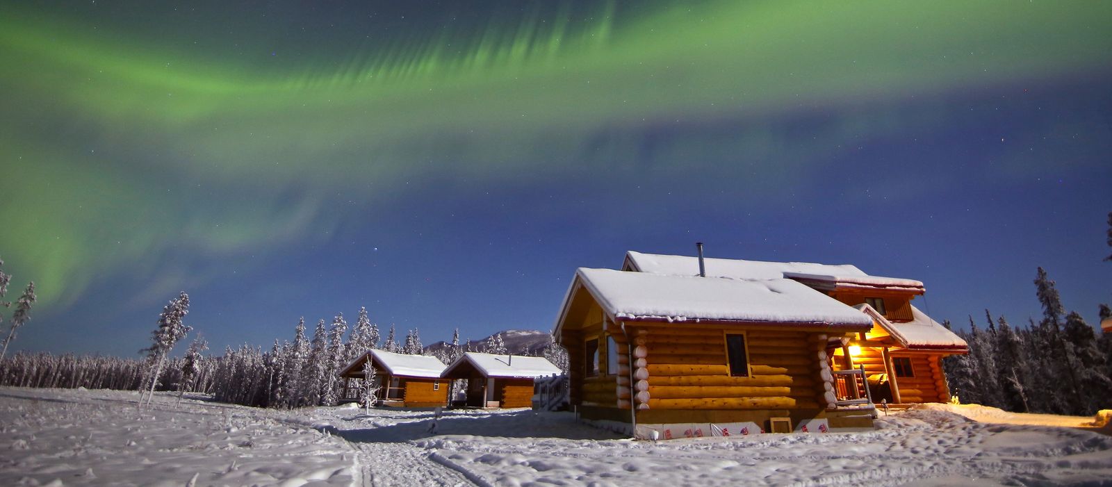 NWT Winter-Promo Yukon, Northern Lights Resort & Spa, Nordlichter über der Lodge