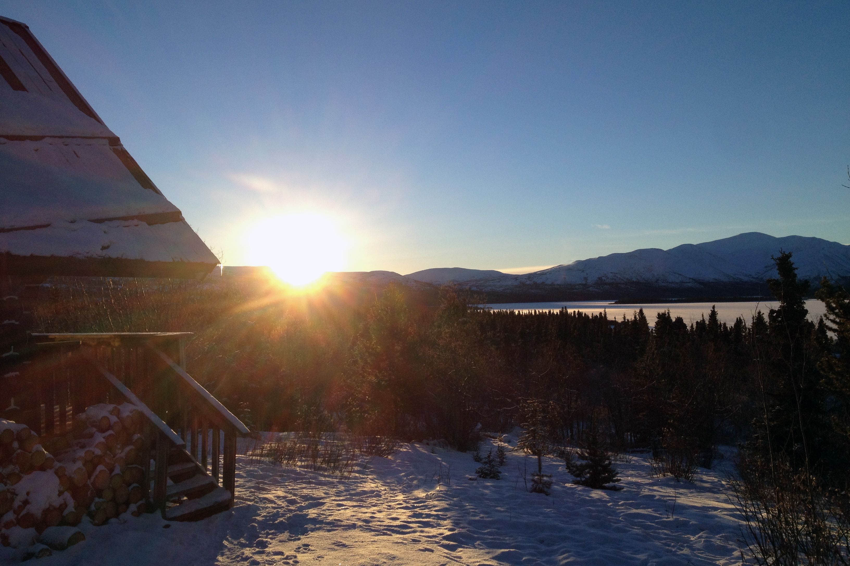 NWT Winter-Promo Yukon, Sky High Wilderness Lodge, AuÃŸenansicht ibei Sonnenuntergang