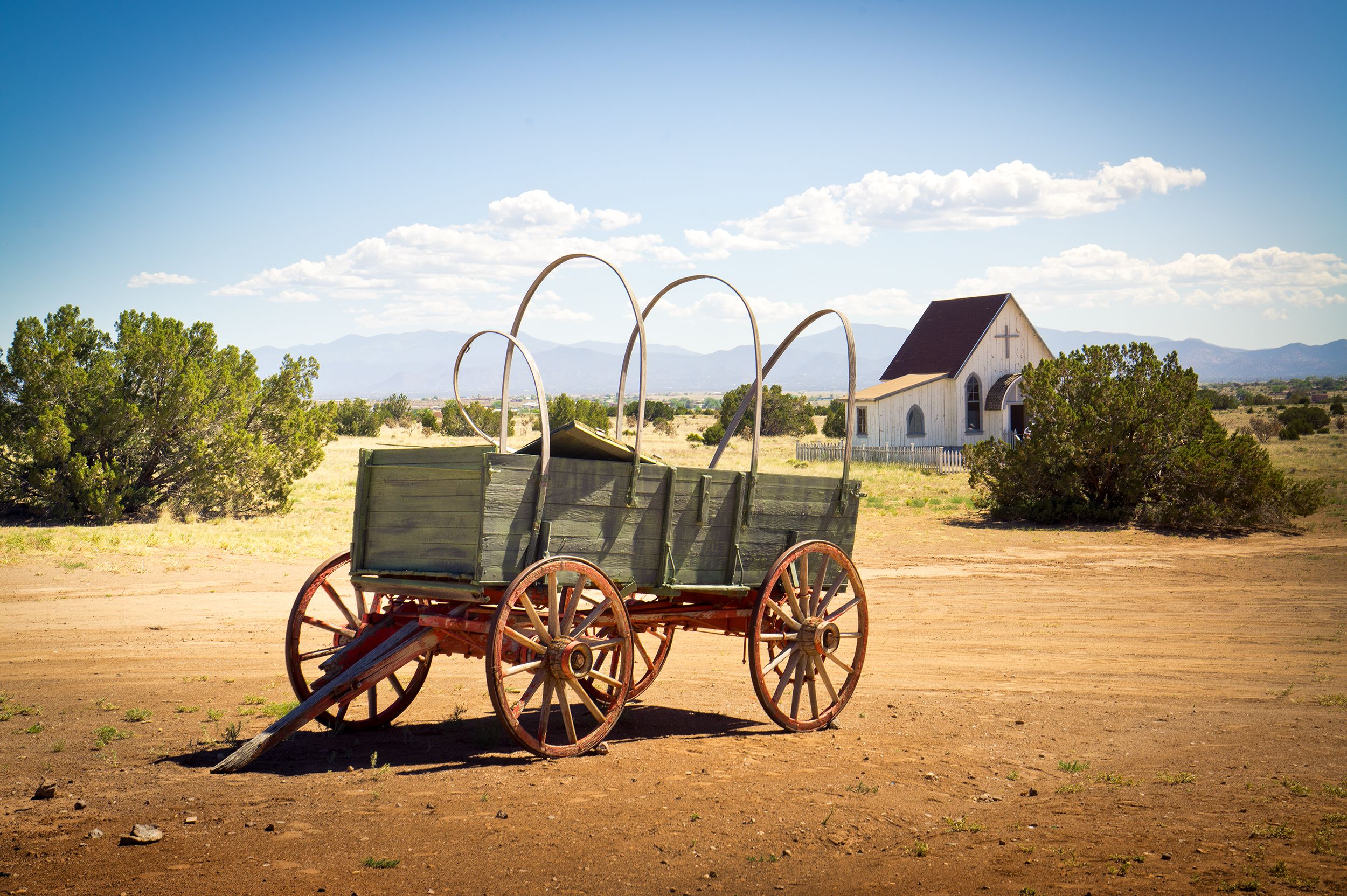 Ein alter Planwagen und eine alte Kirche in der USA