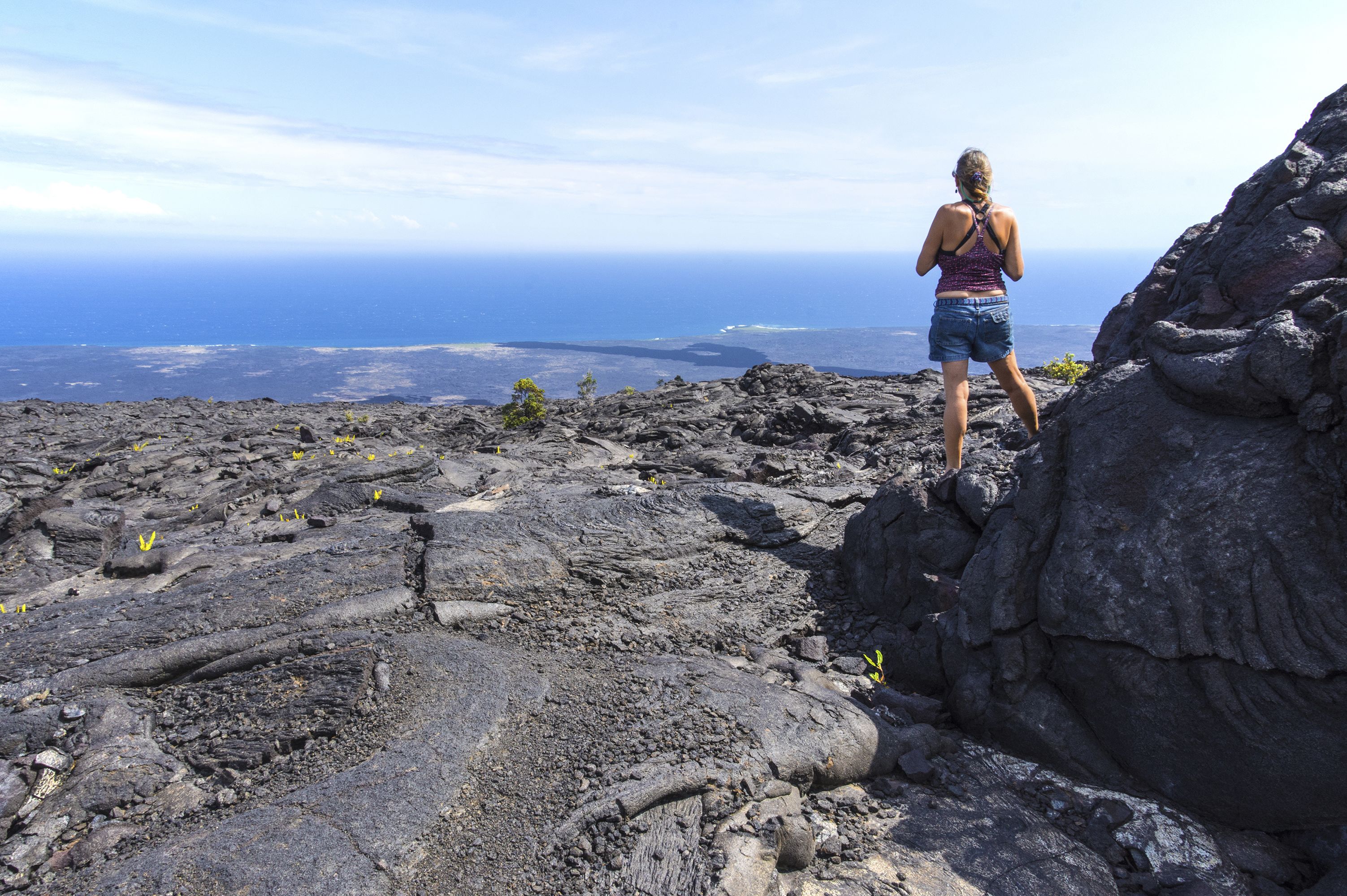 Eine Frau blickt über den Pazifik von der Chain of Craters Road im Hawaii Volcanos National Park auf Big Island, Hawaii