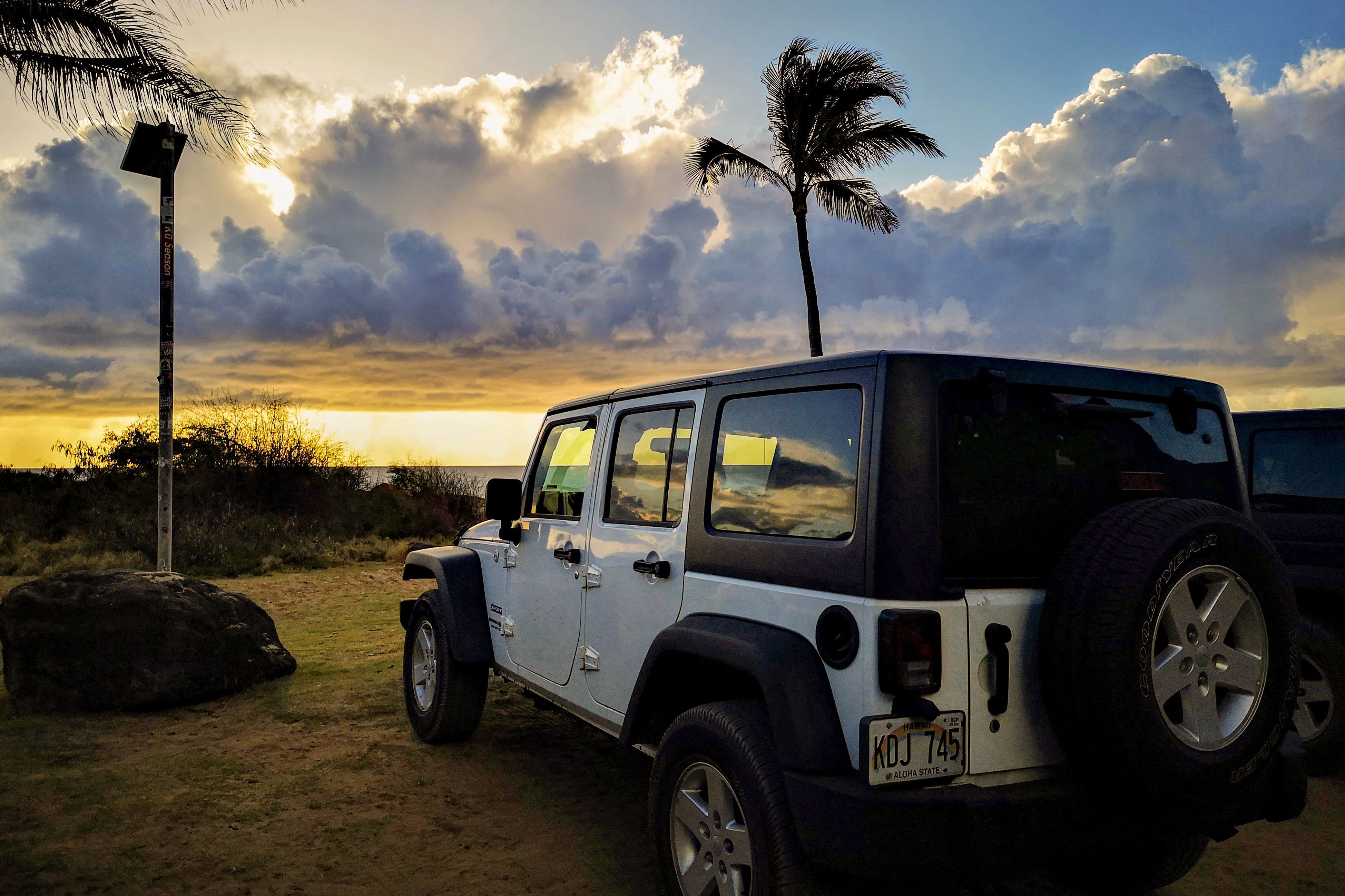 Am Jeep den Sonnenuntergang genießen im Polihale State Park auf Kauai