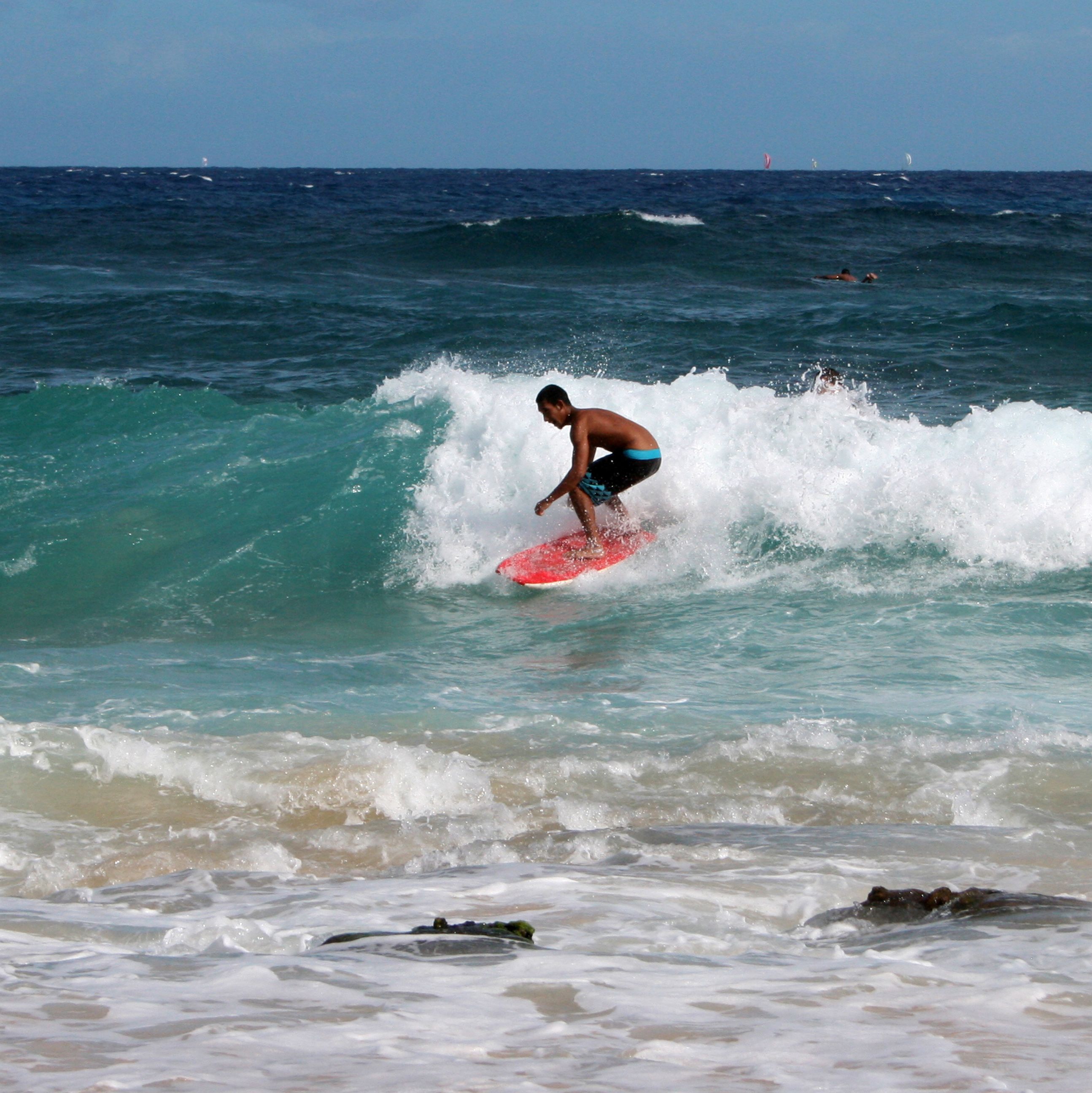 Ein Surfer an der Küste der hawaiischen Insel O'ahu