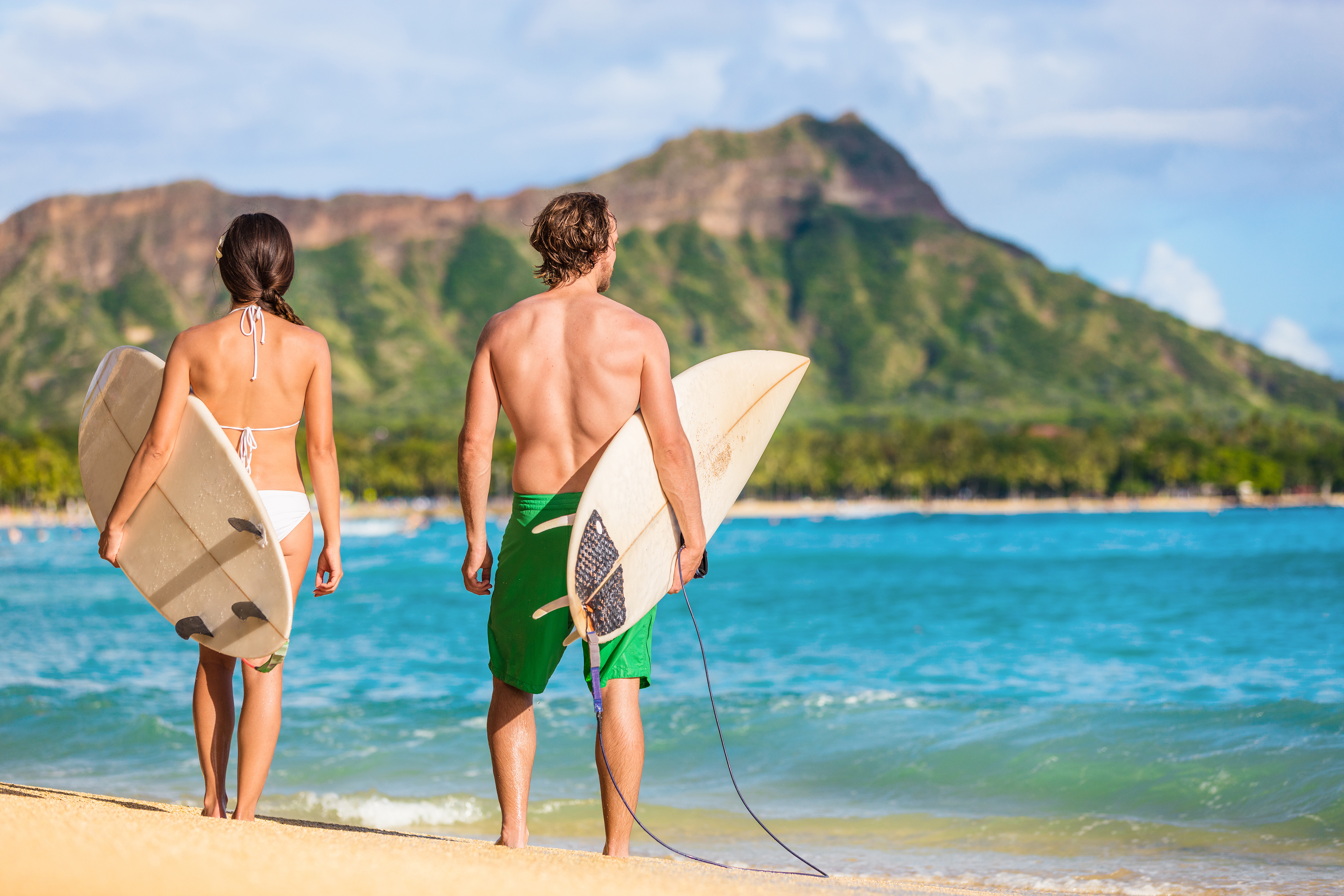 Ein Paar genießt den Strand von Waikiki und das Surfen in Honolulu auf Oahu, Hawaii
