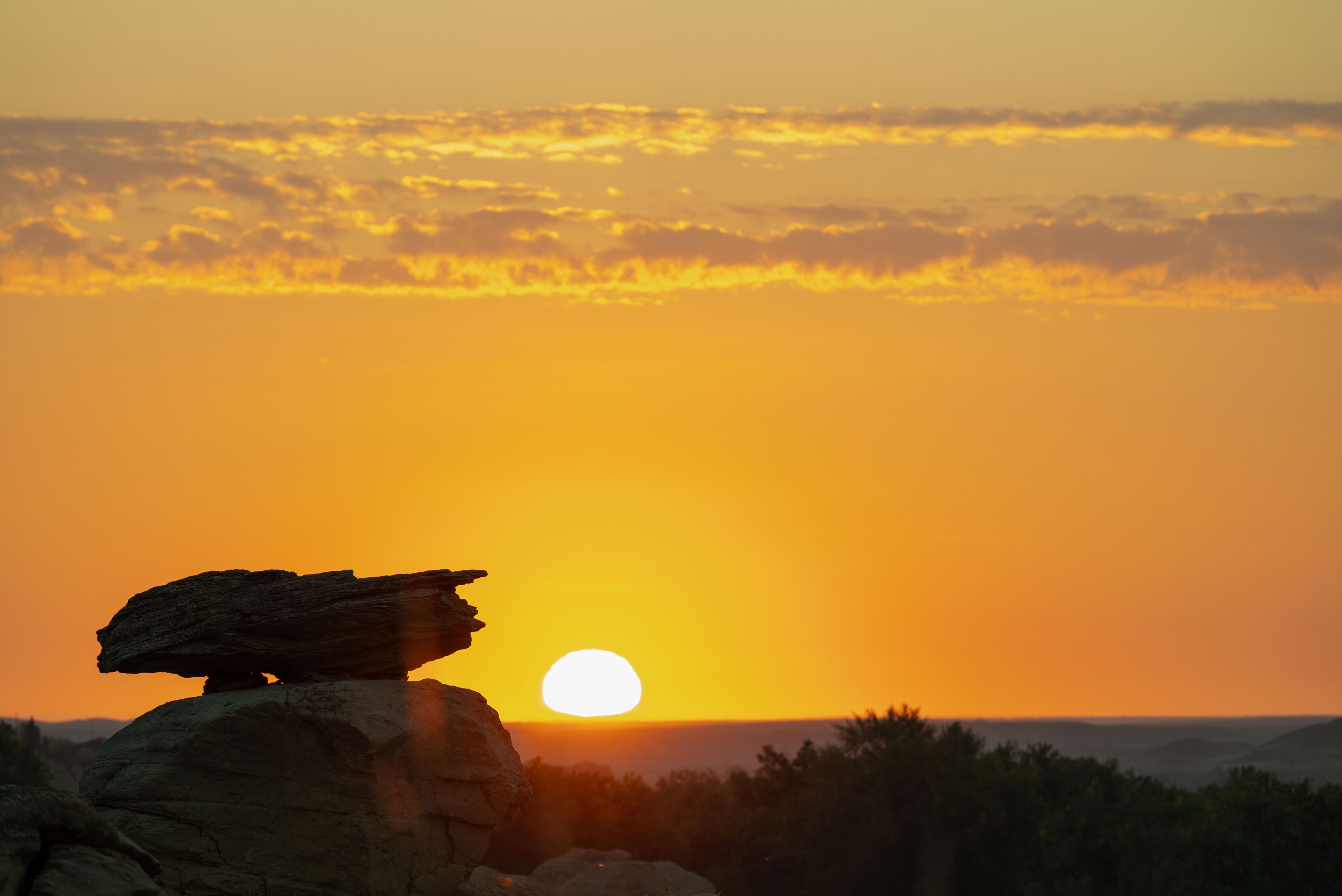 Stimmungsvoller Sonnenuntergang hinter einem markanten Hoodoo in den Canadian Badlands Stimmungsvoller Sonnenuntergang hinter einem markanten Hoodoo in den Canadian Badlands