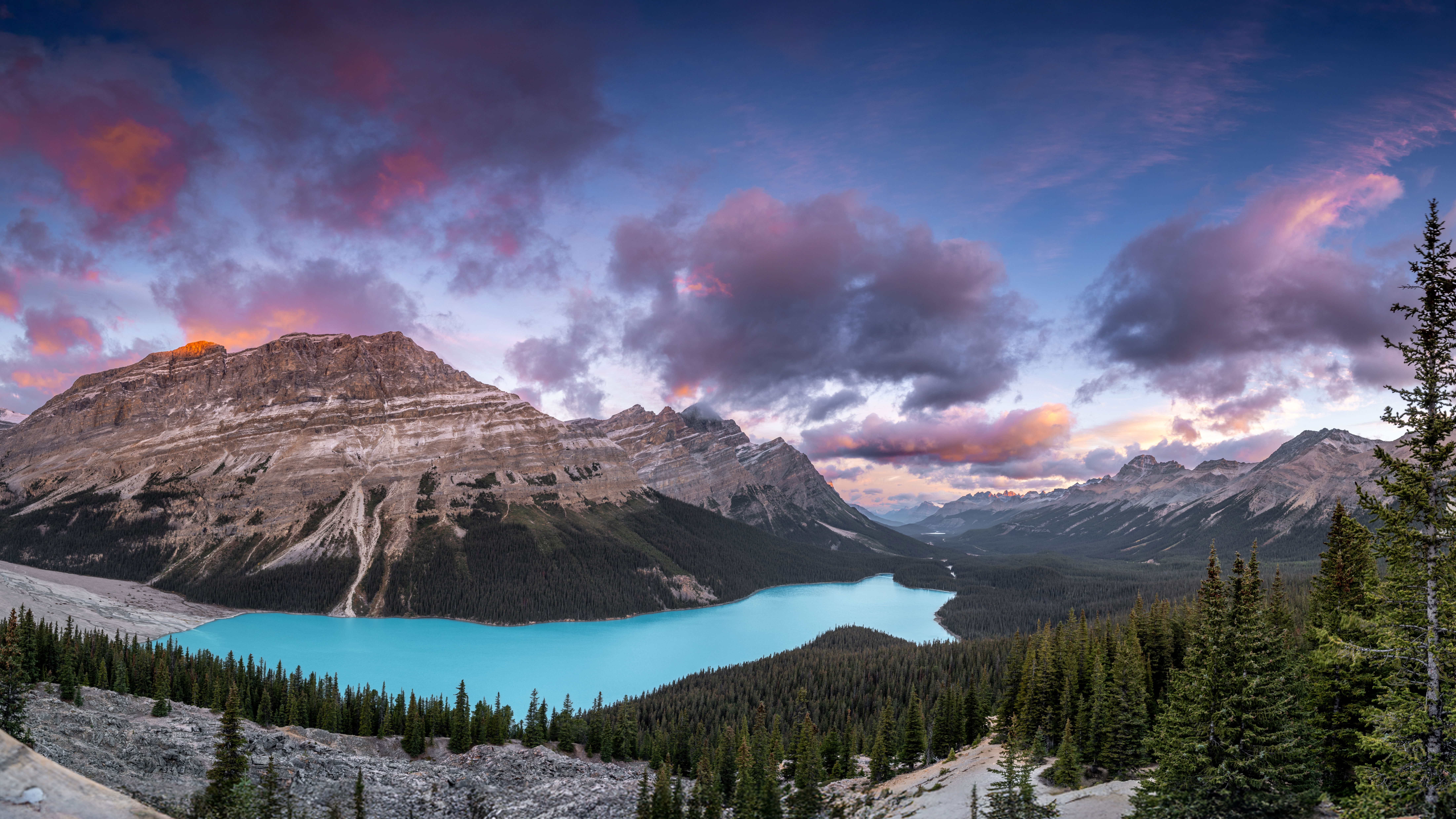 Der leuchtend türkisfarbene Peyto Lake ruht eingebettet in dichte Nadelwälder vor der markanten Bergkulisse des Banff Nationalparks unter einem farbenfrohen Himmel Der leuchtend türkisfarbene Peyto Lake ruht eingebettet in dichte Nadelwälder vor der markanten Bergkulisse des Banff Nationalparks unter einem farbenfrohen Himmel