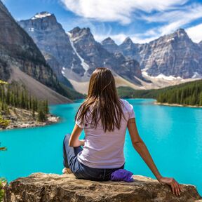 Eine Frau in traumhafter Landschaft am Moraine Lake in Alberta