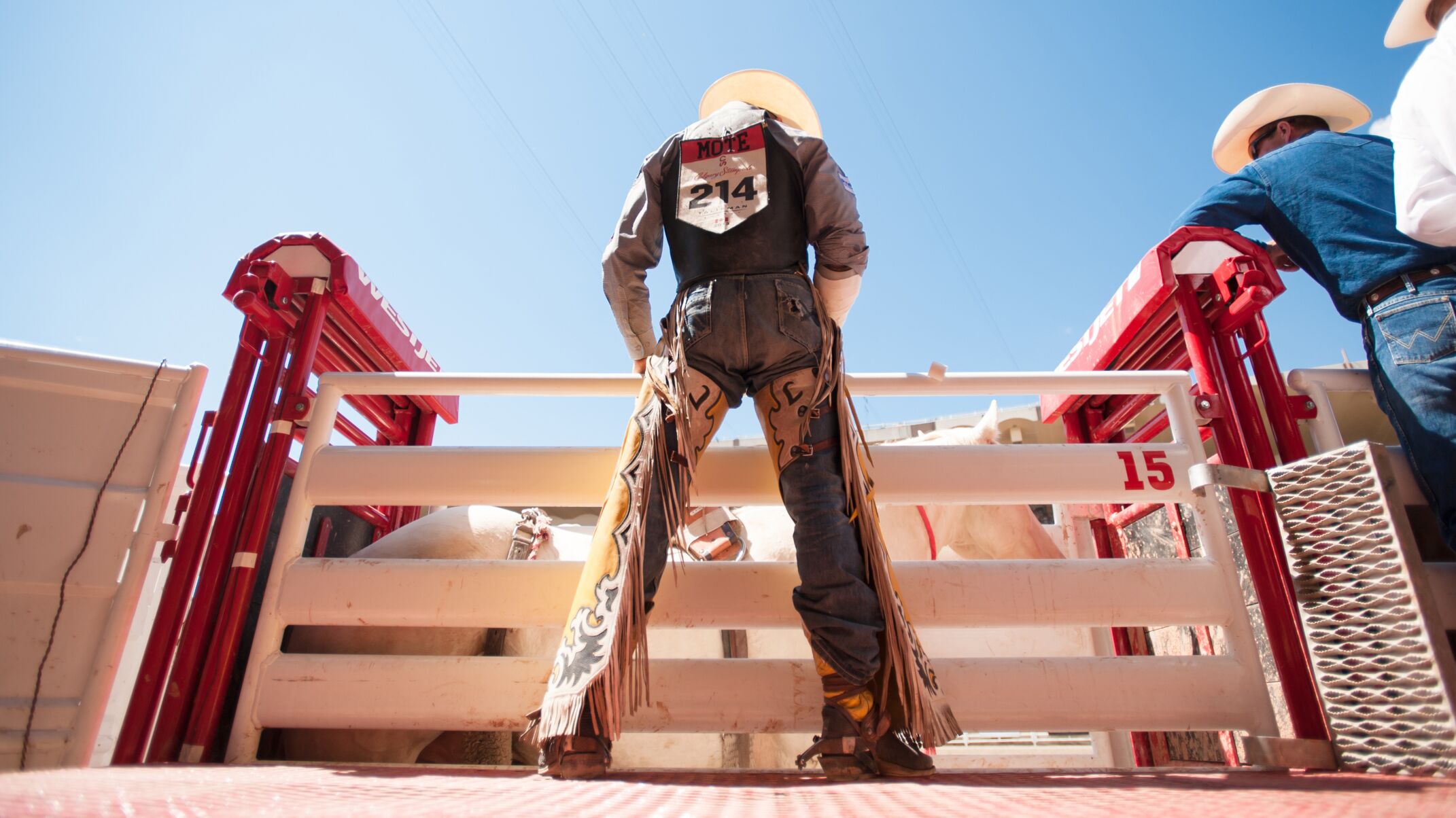Ein Cowboy wartet auf den Beginn des Rodeos Ein Cowboy wartet vor einem Gatter auf den Beginn des Rodeos