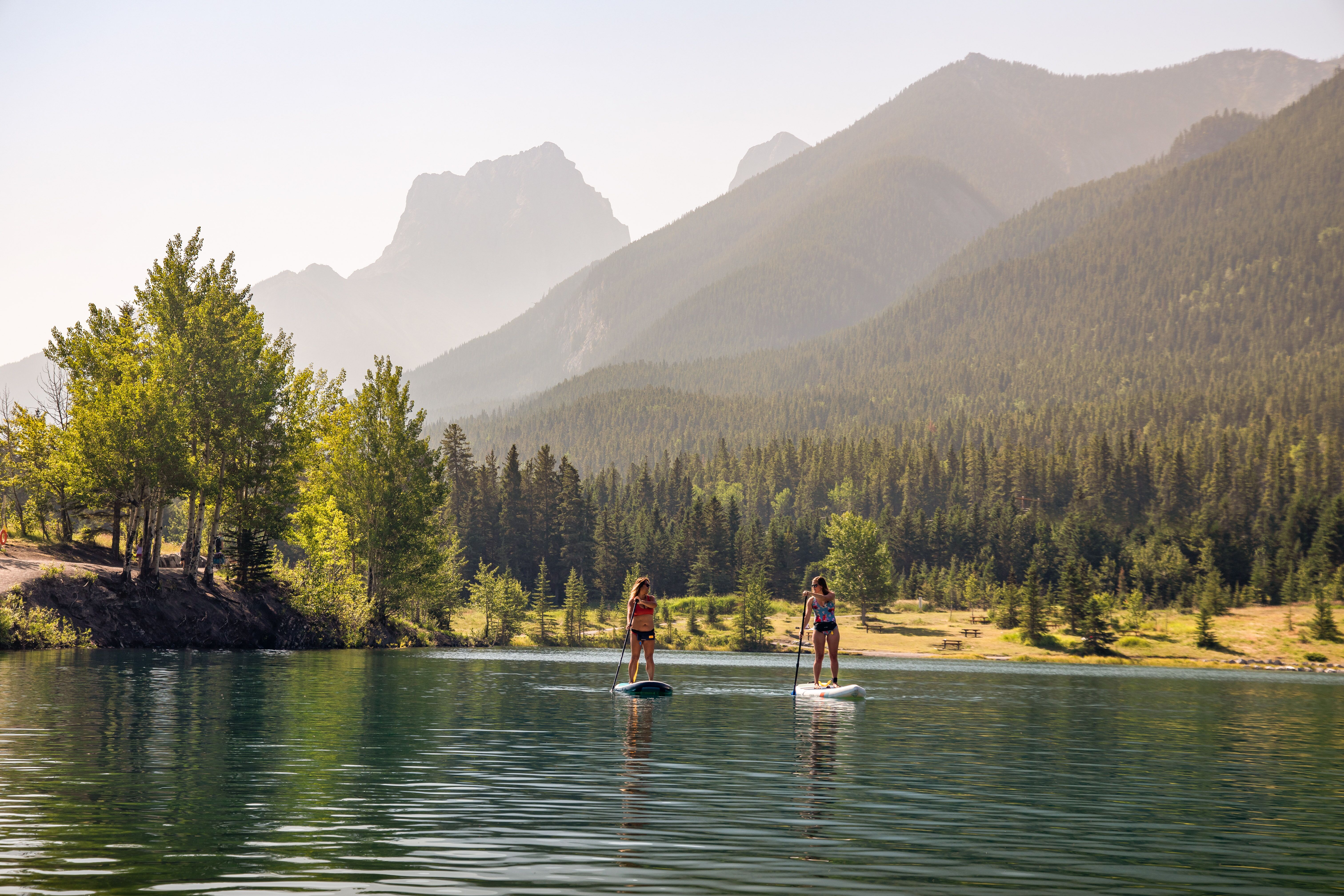 Zwei Frauen paddeln durch einen wundervollen Bergsee in Canmore