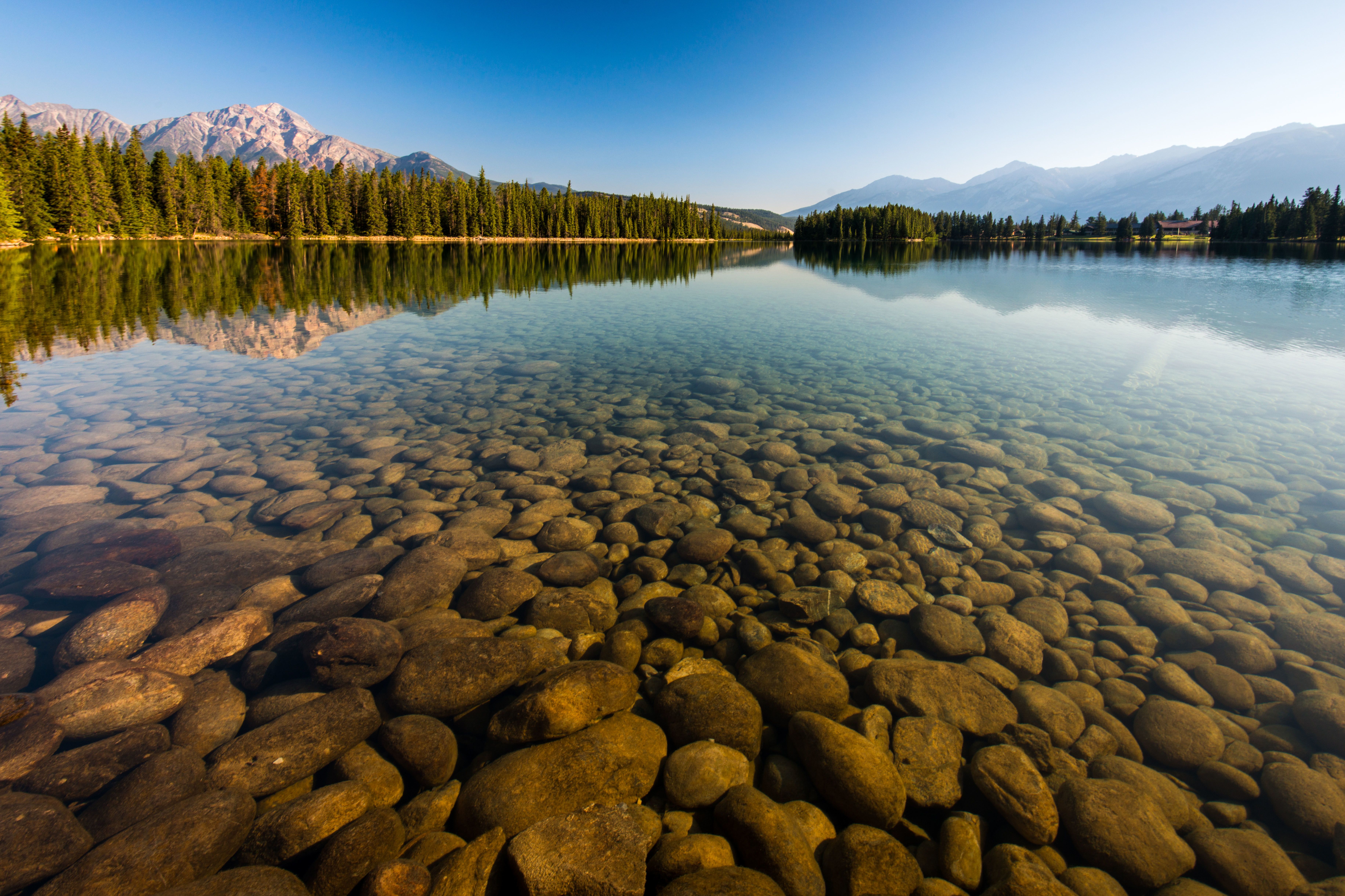 Kieselsteine im klaren Wasser des Lac Beauvert mit Pyramid Mountain im Jasper National Park, Alberta