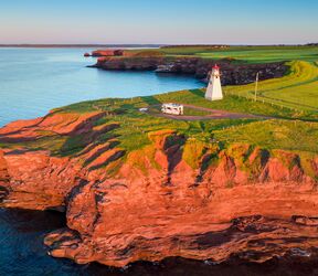 Blick auf das East Point Lighthouse auf Prince Edward Island im Sonnenuntergang mit einem Wohnmobil davor Blick auf das East Point Lighthouse auf Prince Edward Island im Sonnenuntergang mit einem Wohnmobil davor