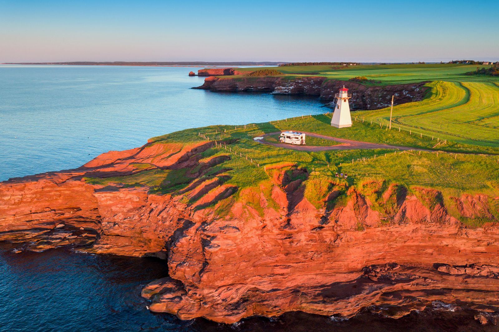 Blick auf das East Point Lighthouse auf Prince Edward Island im Sonnenuntergang mit einem Wohnmobil davor