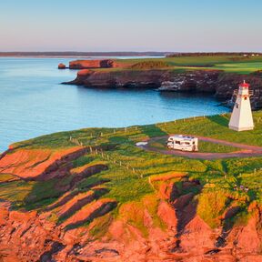 Blick auf das East Point Lighthouse auf Prince Edward Island im Sonnenuntergang mit einem Wohnmobil davor