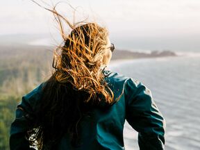 Eine Frau blickt im Naikoon Provincial Park auf das Meer