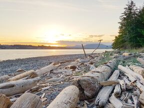 Blick von Quadra Island auf den Sonnenuntergang hinter Campbell River auf Vancouver Island, British Columbia
