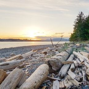 Blick von Quadra Island auf den Sonnenuntergang hinter Campbell River auf Vancouver Island, British Columbia