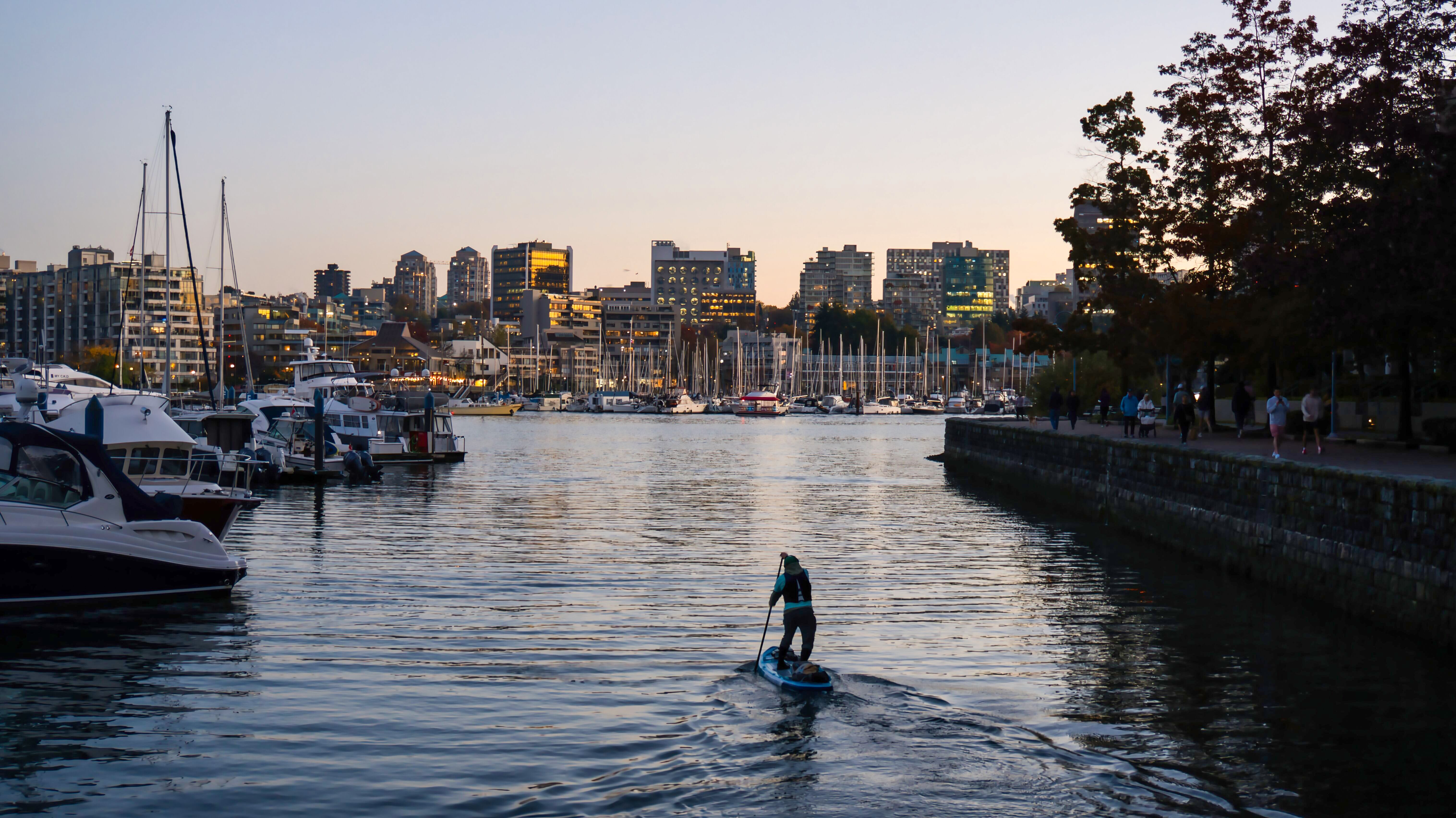 Ein Mann beim Stand-Up-Paddeln am Hafen in Yaletown