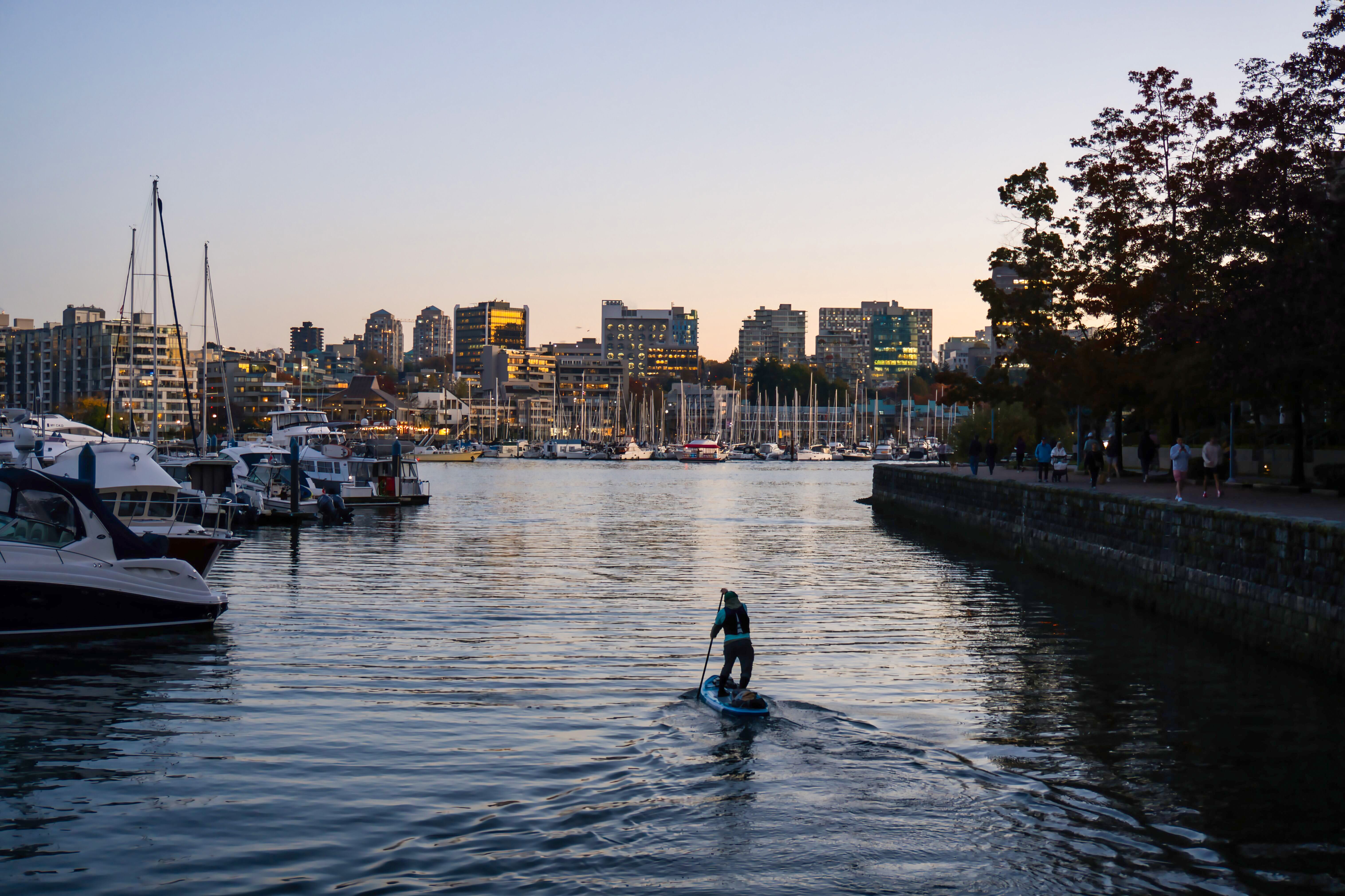 Ein Mann beim Stand-Up-Paddeln am Hafen in Yaletown 
