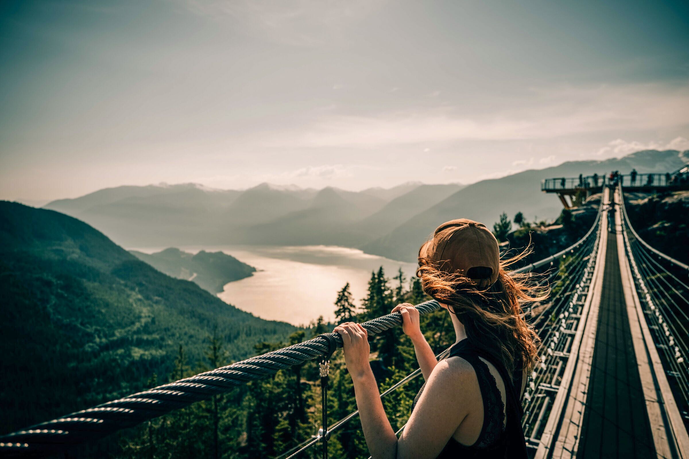 Frau sieht von der Sky Pilot Suspension Bridge aus auf die Landschaft