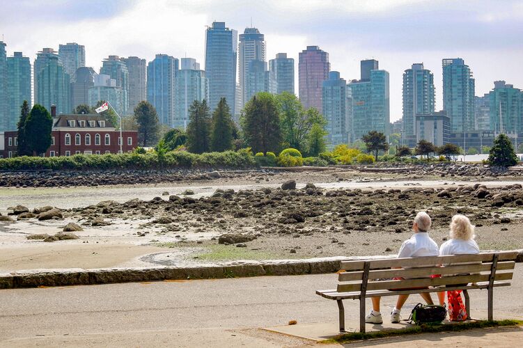 Ein PÃ¤rchen genieÃŸt die Aussicht auf die Skyline von Vancouver im Stanley Park