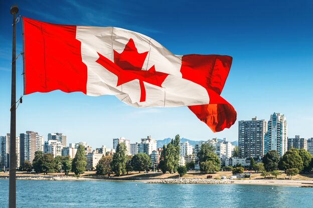 Die kanadische Flagge weht vor der Skyline von Vancouver
