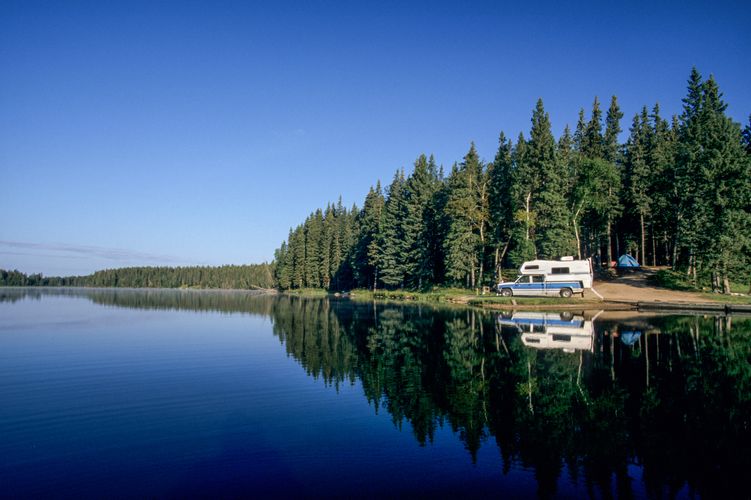 Ein Camper am Ufer eines Sees in der Parkland Region in Manitoba
