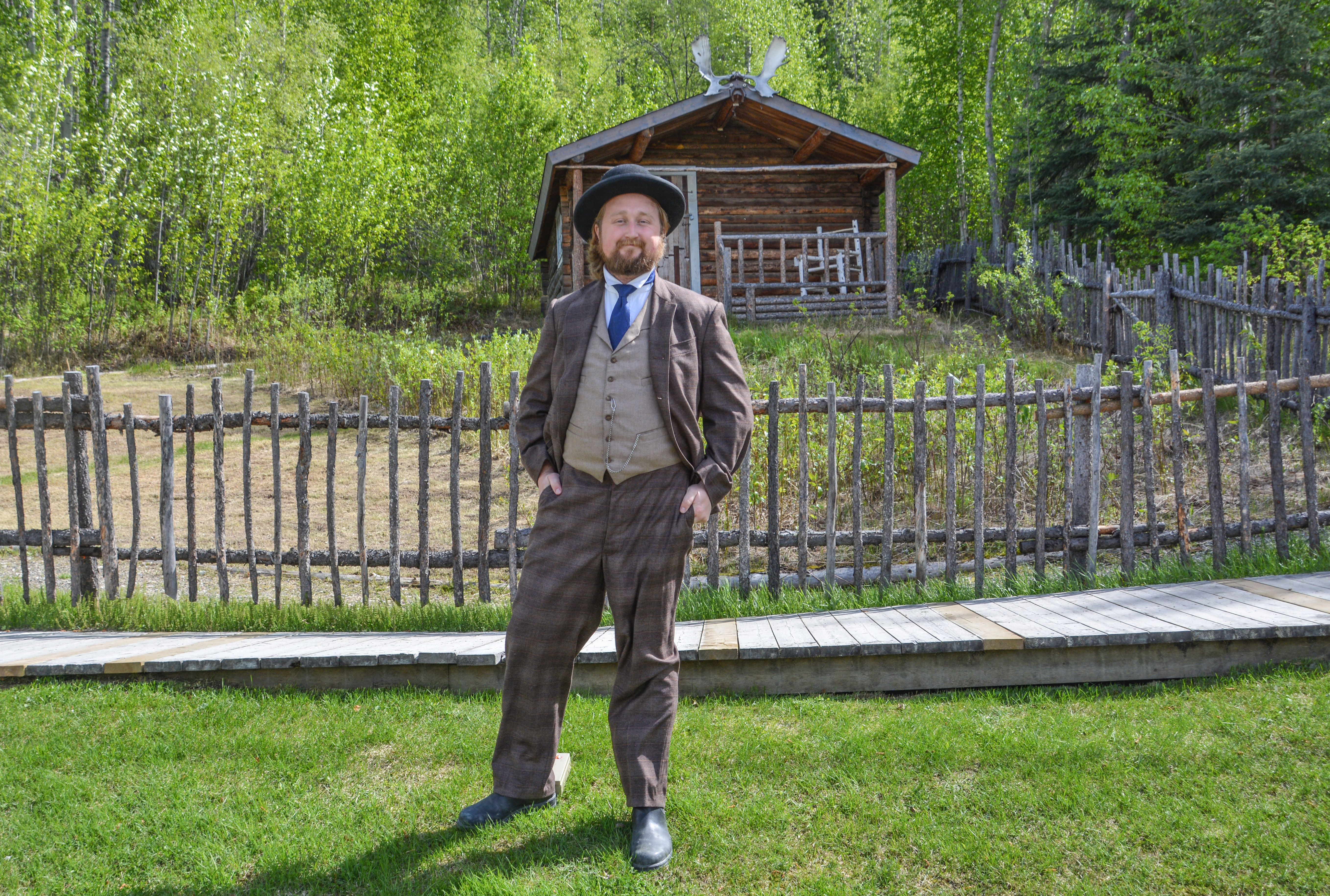 Ein Mitarbeiter der Dawson Historical Complex National Historic Site vor der HÃ¼tte des kanadischen Dichters Robert W. Service in Dawson City, Yukon