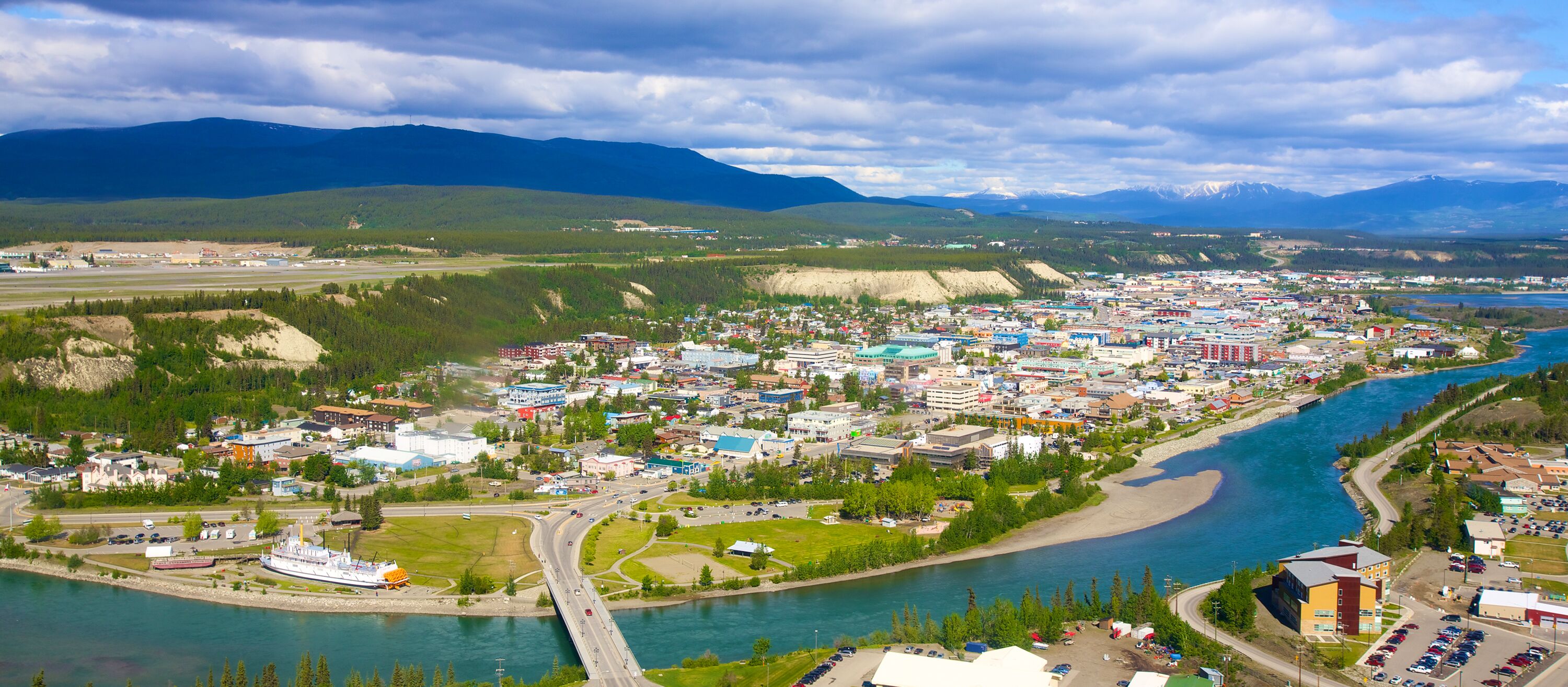 Luftansicht von Whitehorse im Yukon. Die Stadt umgeben von Bergen und dem Yukon River.