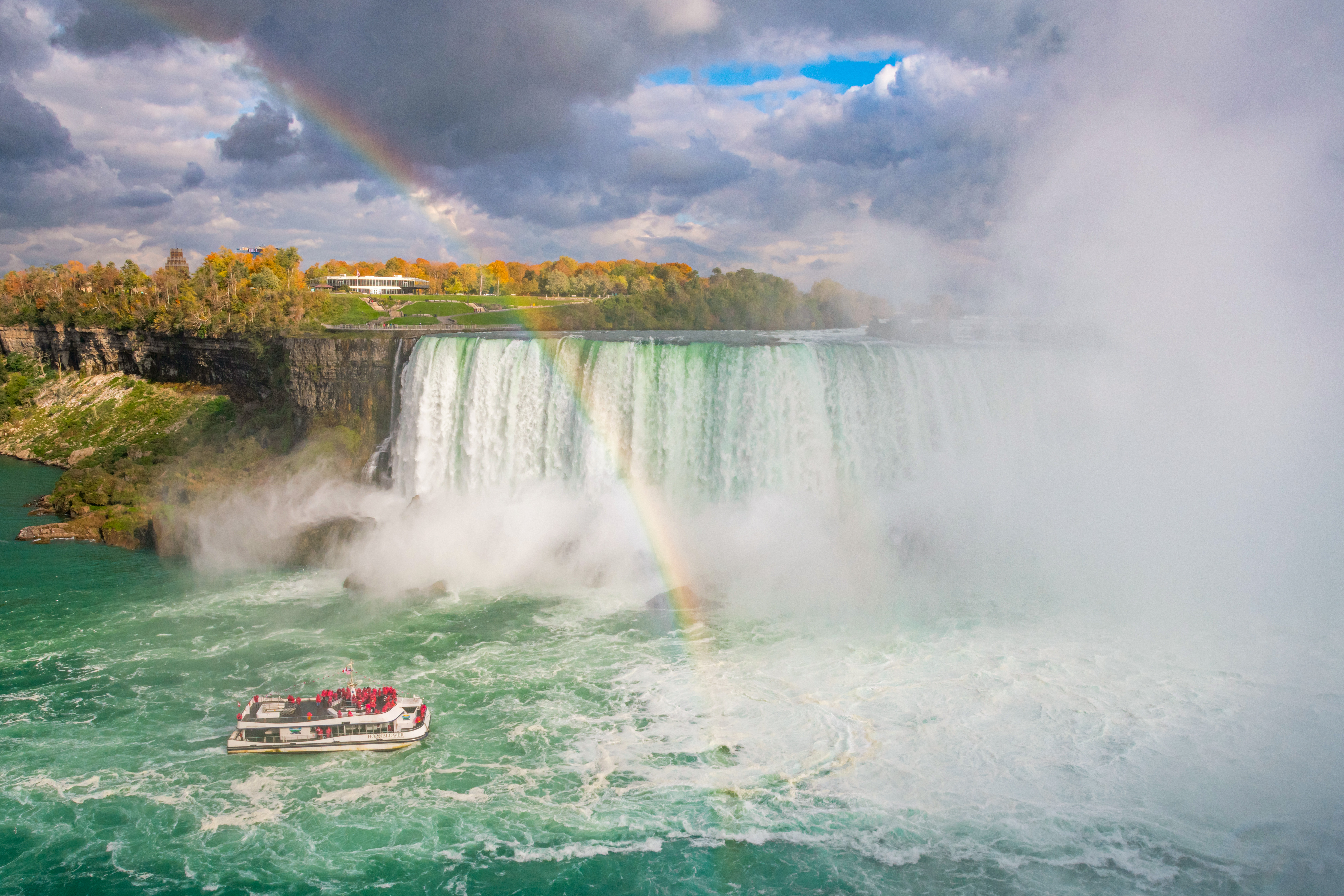 Ein Boot der Hornblower Cruise und ein Regenbogen vor den Niagarafällen, Ontario