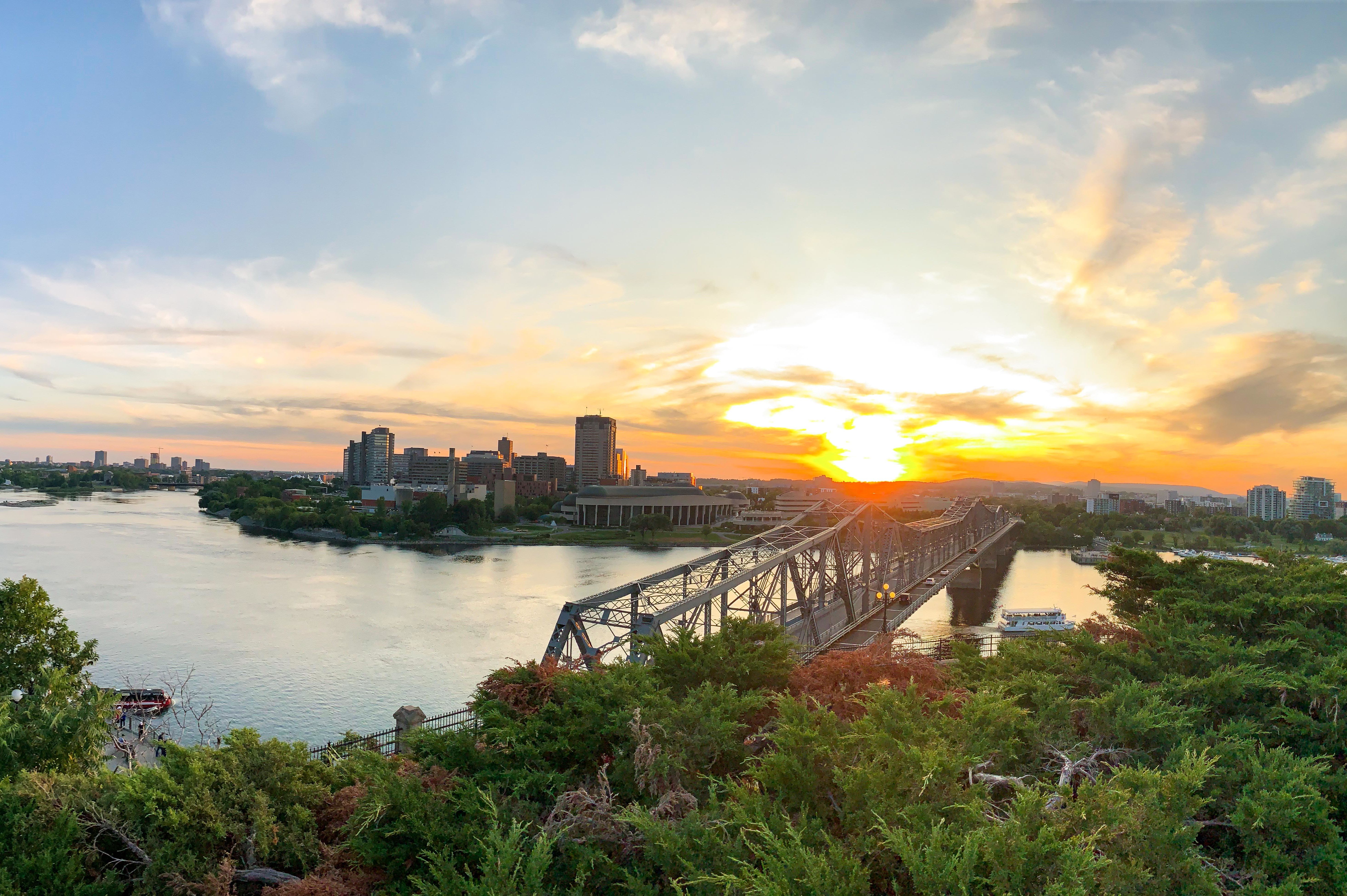 Malerischer Blick bei Sonnenuntergang über den Parliament Hill und die Alexandra Bridge in Ottawa, Ontario