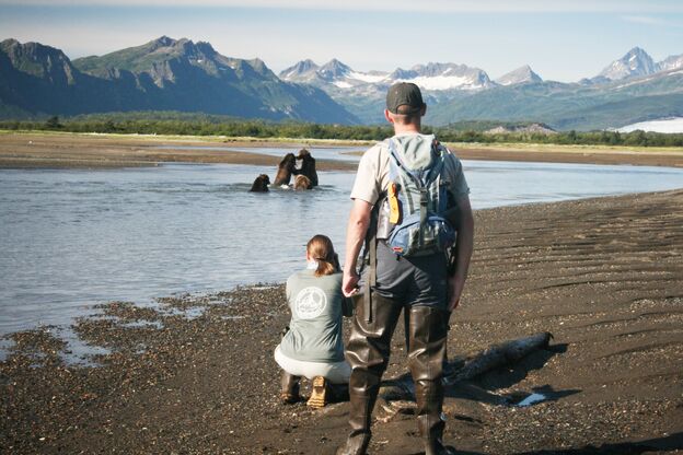 Mann und Frau bei Bärenbeobachtung in Homer, Alaska Mann und Frau bei Bärenbeobachtung in Homer, Alaska