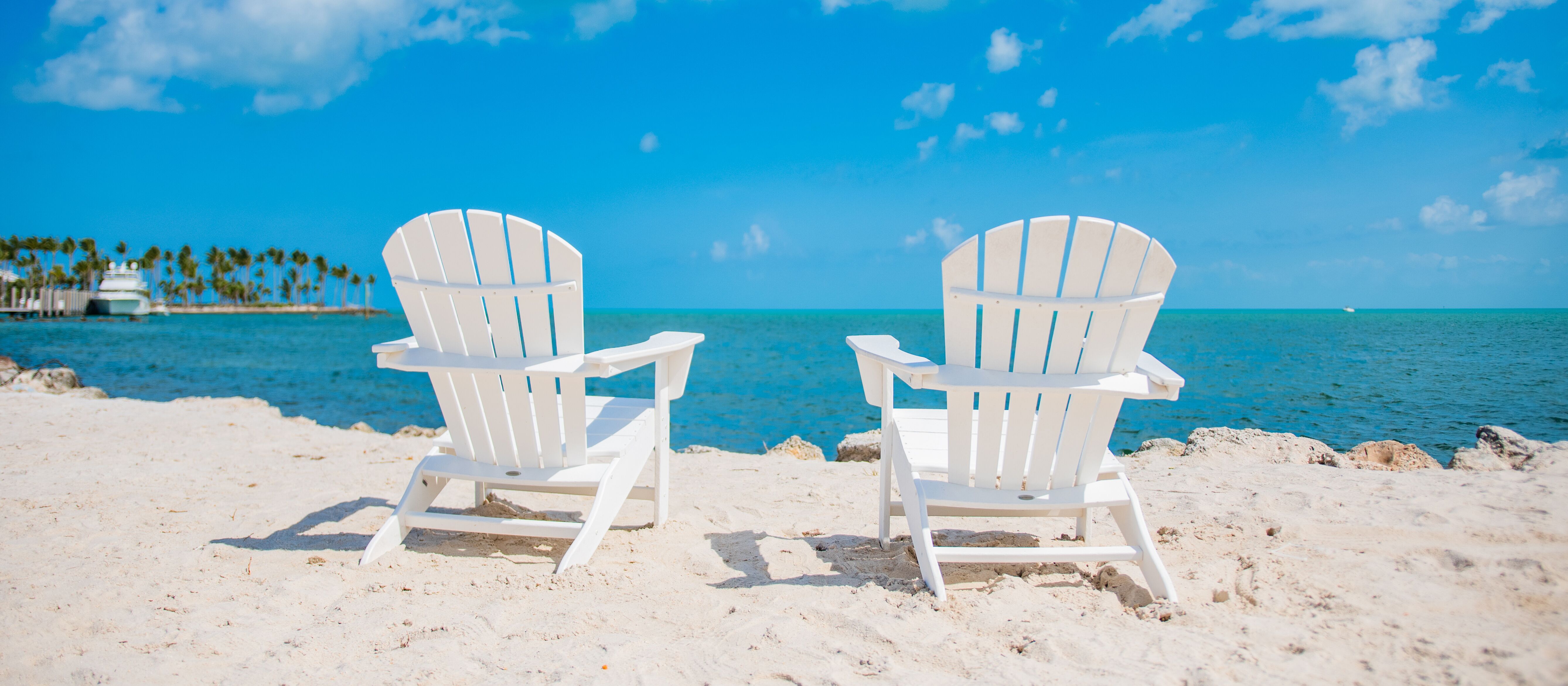 Weiße Stühle am Strand