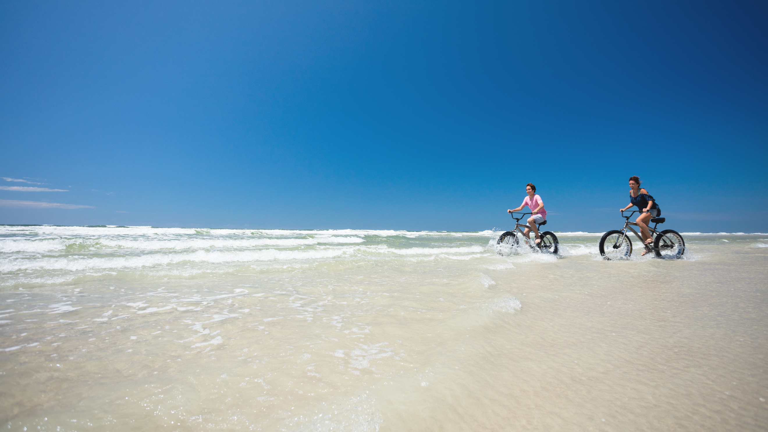Mutter und Sohn unterwegs auf Beach Cruisern in New Smyrna Beach
