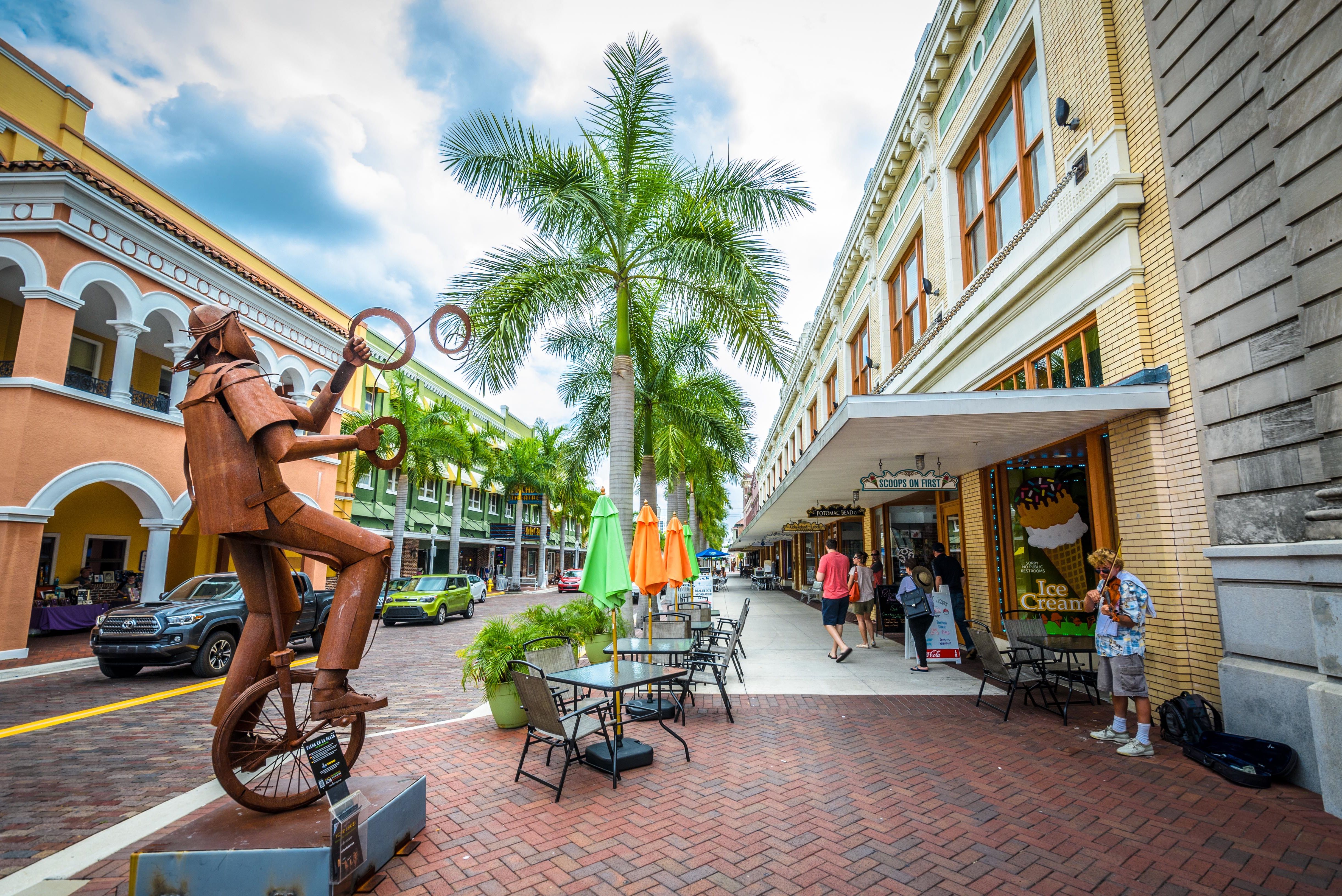 Jongleur auf einem Einrad - eine Metallskulptur von Edgardo Carmona auf der Fist Street in Fort Myers