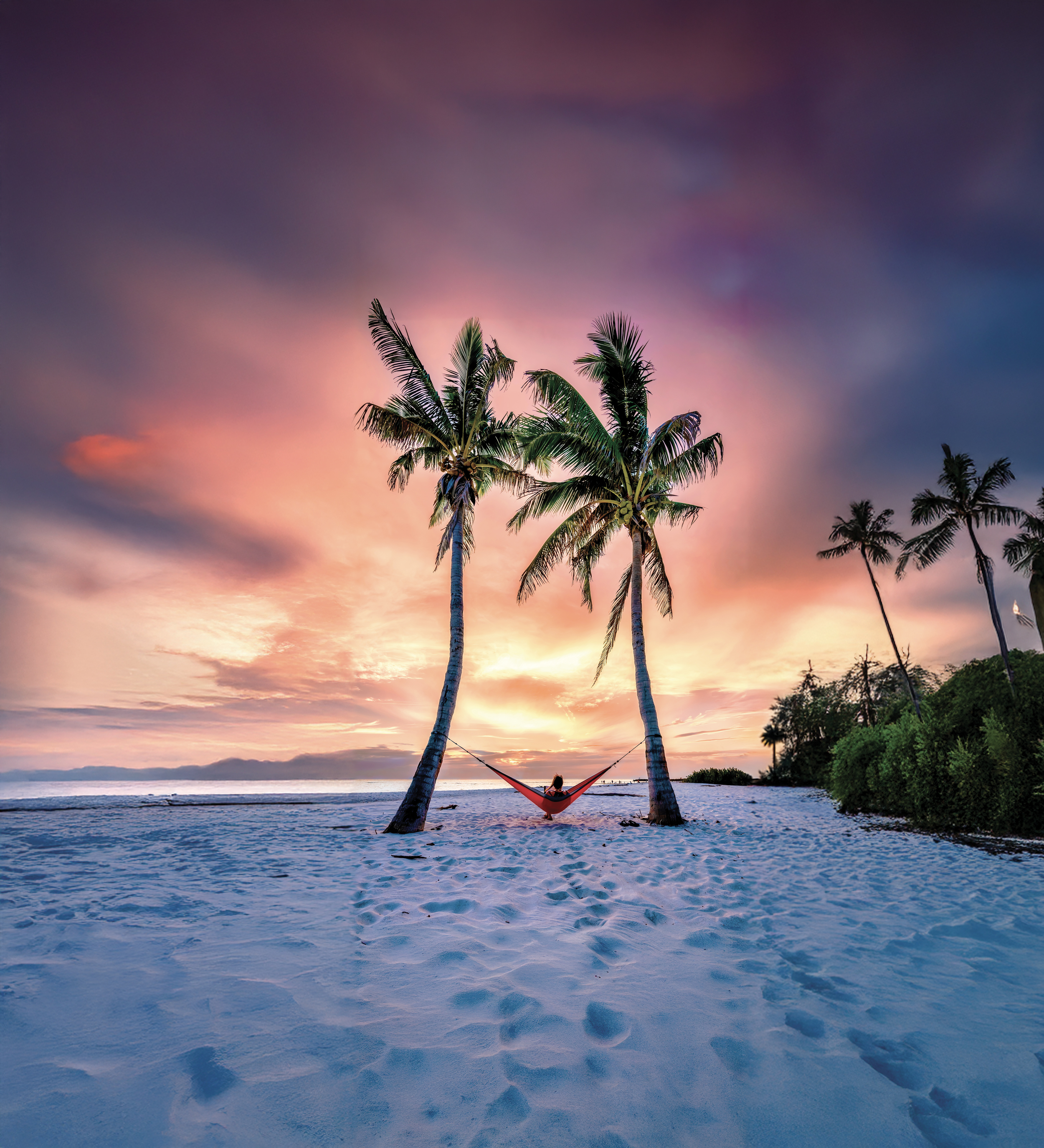 Auf einer Hängematte unter Palmen den Sonnenuntergang in Fort Myers genießen Auf einer Hängematte unter Palmen den Sonnenuntergang in Fort Myers genießen