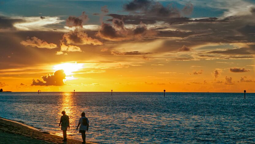 Zwei Spaziergänger im Sonnenuntergang am Smathers Beach auf Key West, Florida Keys, Florida Zwei Spaziergänger im Sonnenuntergang am Smathers Beach auf Key West, Florida Keys, Florida
