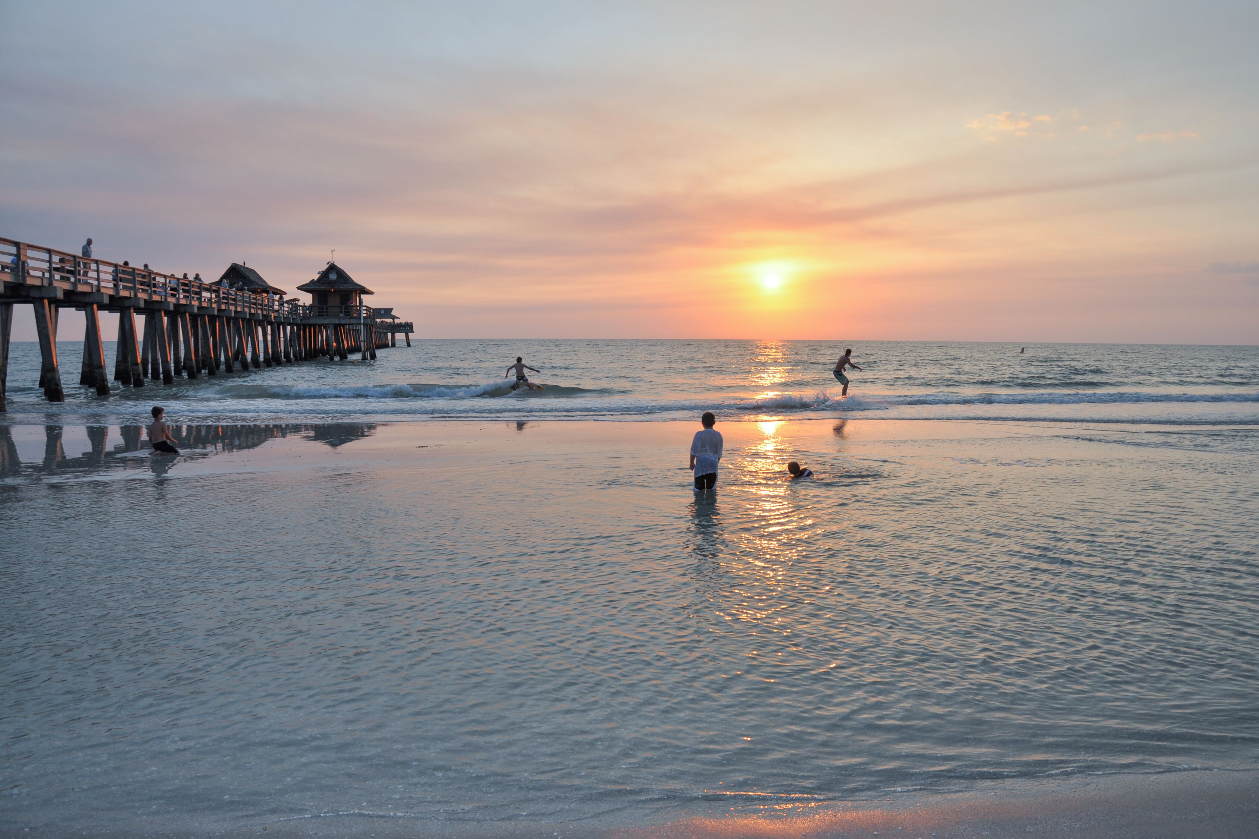 BadespaÃŸ im Sonnenuntergang am Naples Pier in Florida