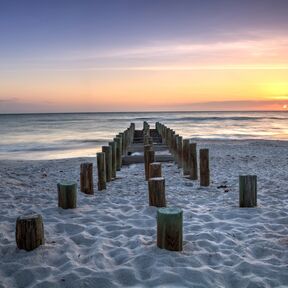 Die Ãœberreste des alten Pier am Strand von Naples bei Sonnenuntergang