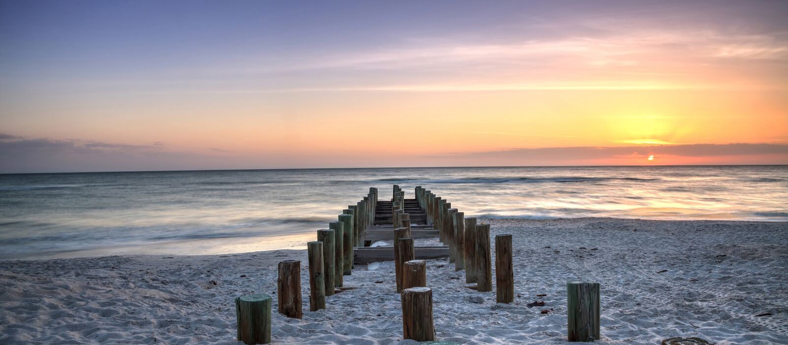 Die Ãœberreste des alten Pier am Strand von Naples bei Sonnenuntergang