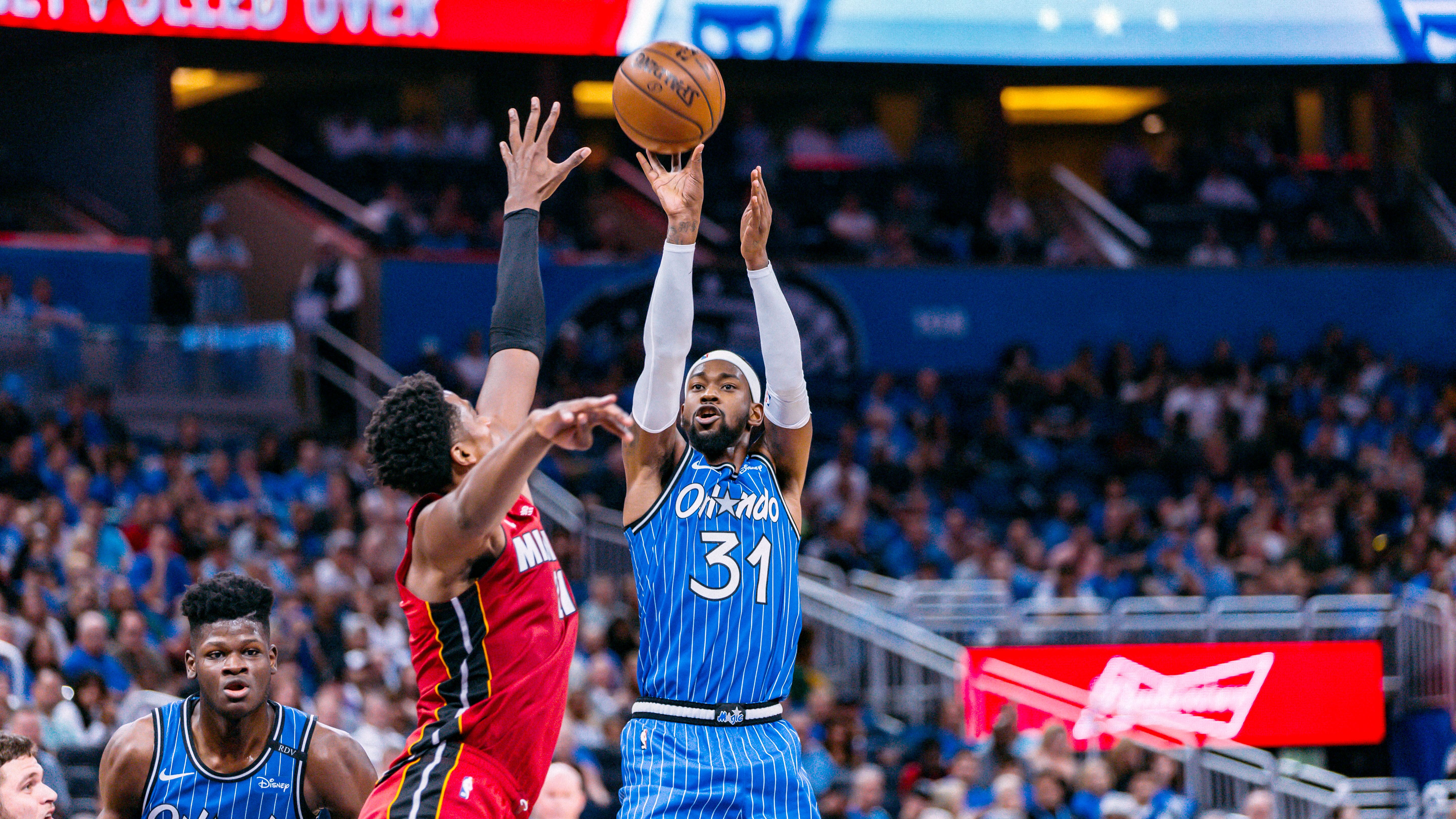 Basketballspiel zwischen den Orlando Magic und den Miami Heat in der Arena in Orlando, Florida. Ein Spieler der Orlando Magic wirft den Ball, während ein Spieler der Miami Heat versucht, ihn zu blocken.