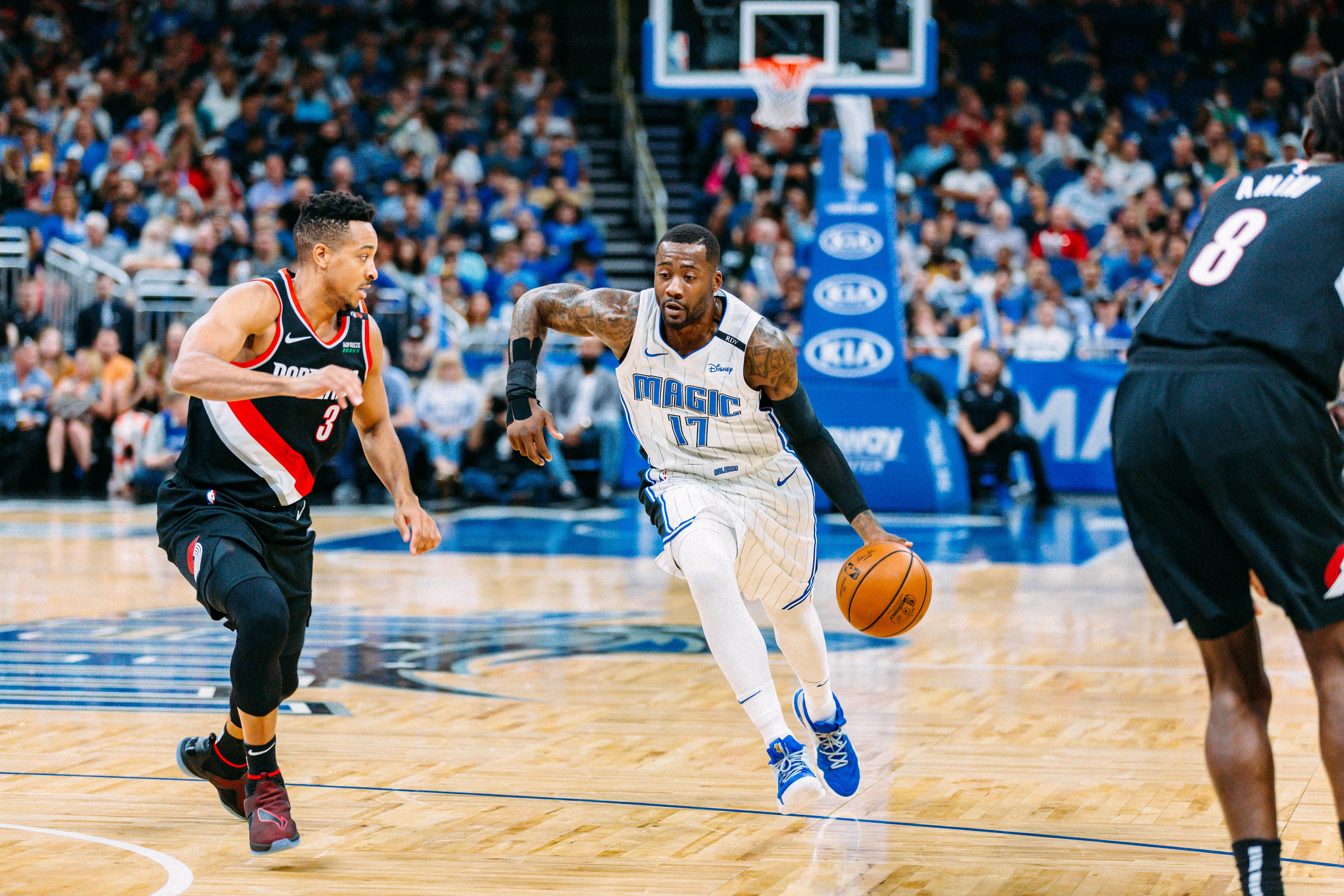 Ein Spieler der Orlando Magic dribbelt den Ball gegen zwei Verteidiger der Portland Trail Blazers während eines Basketballspiels in Orlando, Florida.

